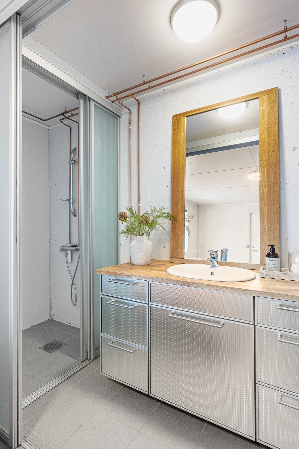 Bad i garasje med dusj, wc og innredning med servant og speil. Galleribilde