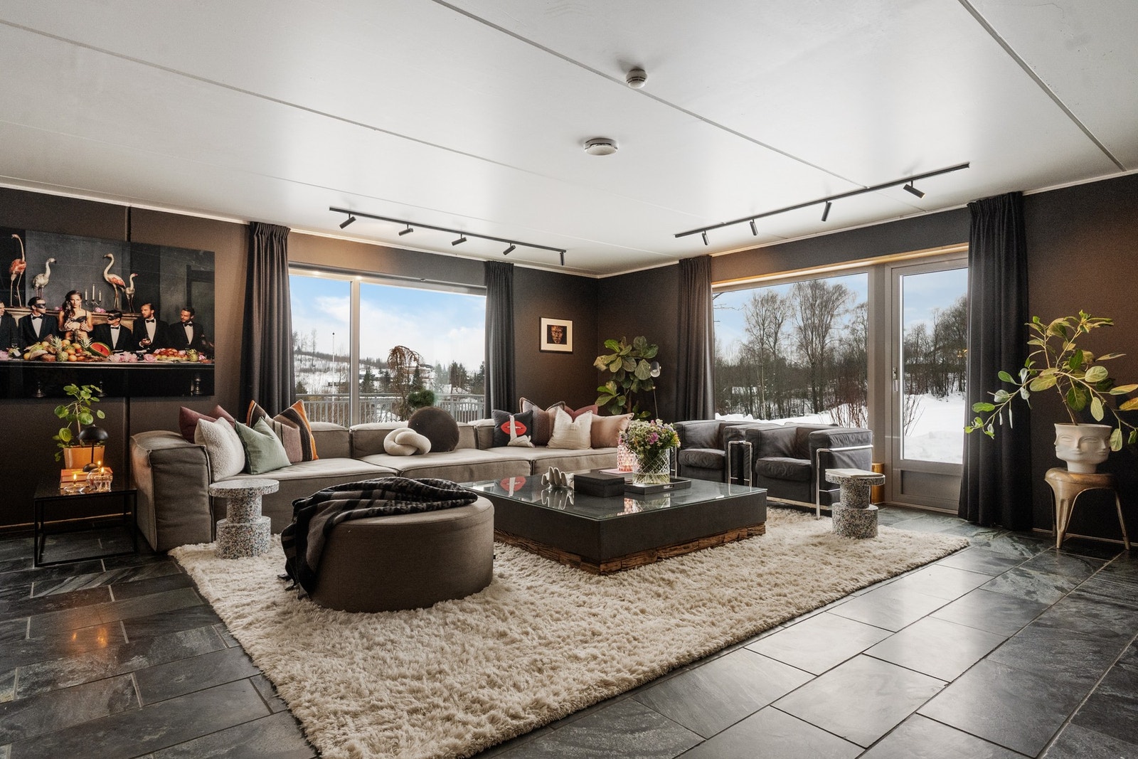 Stuen er holdt i eksklusive mørke toner med store vinduer. Galleribilde