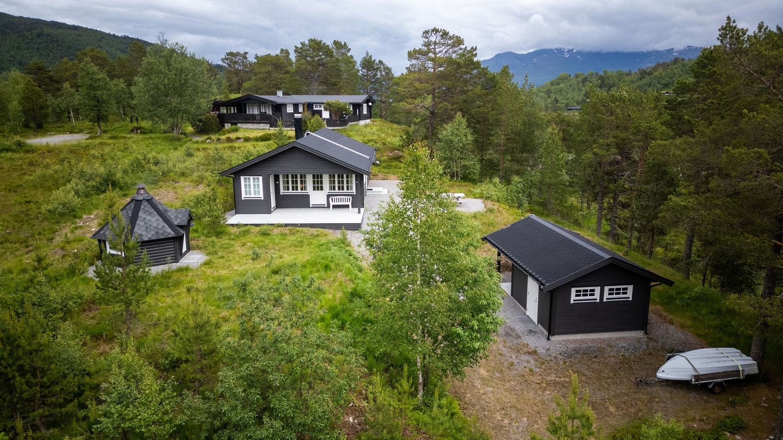 Dronebilde av hytte, uthus og grillhus Galleribilde