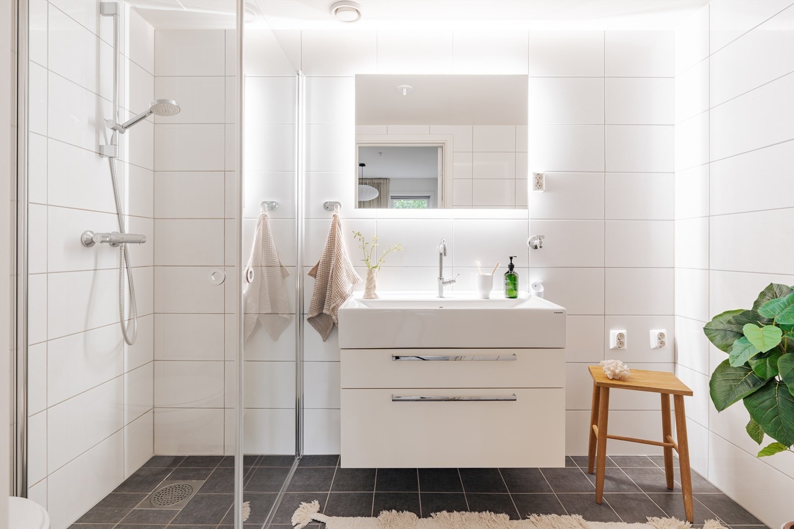 Det private badet er helfliset og utstyrt med dusjhjørne og vegghengt toalett. Galleribilde