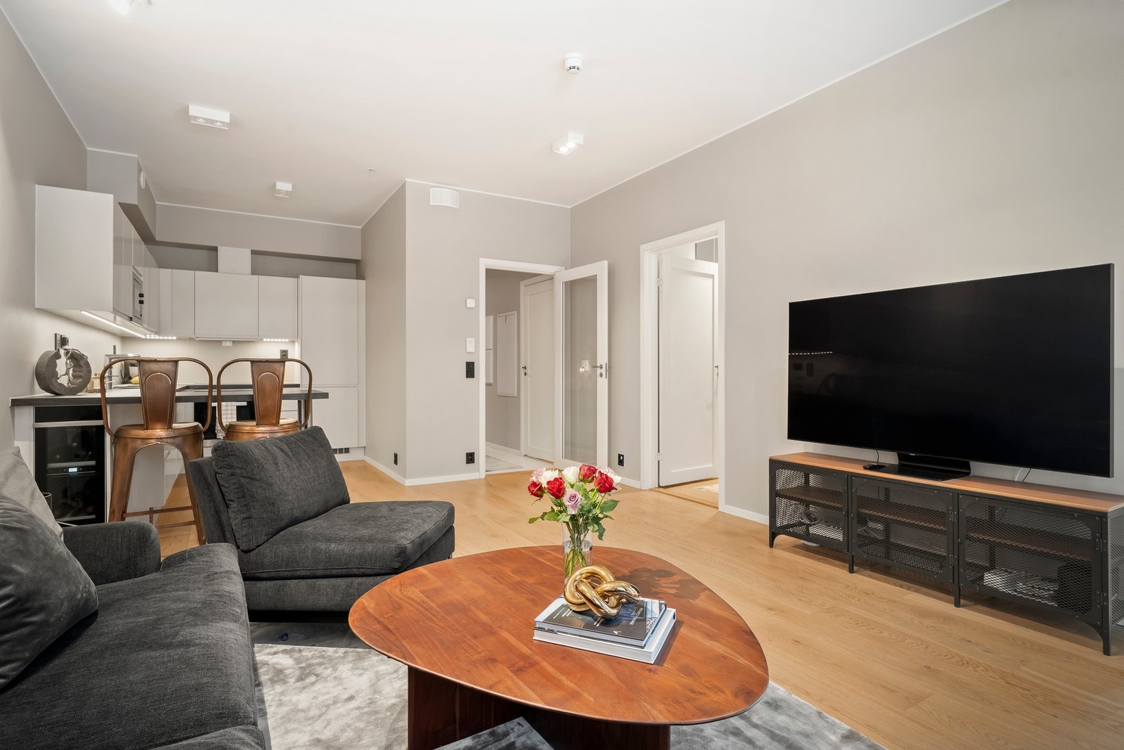 Både stuen og kjøkkenet har enstavs parkett, malte vegger i en mørk sandfarge og downlights i himling. Galleribilde