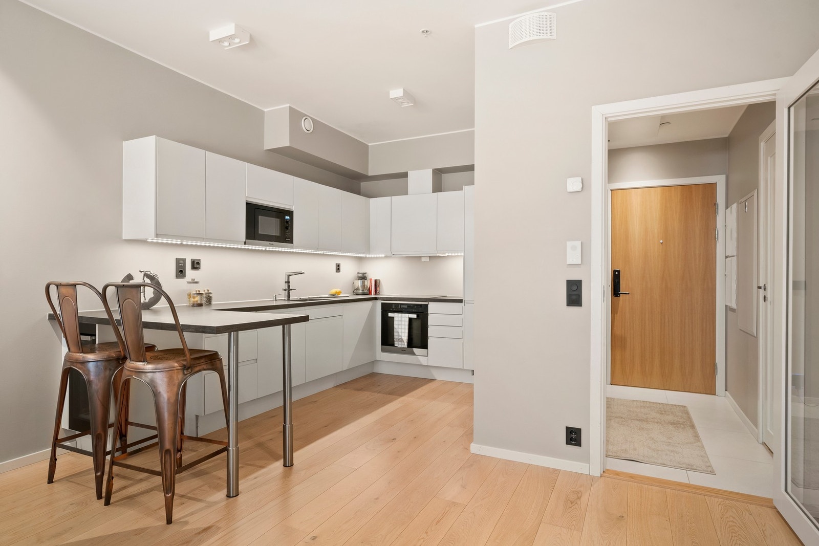 Kjøkkenet ligger i vellykket åpning med stuen, og har en barløsning med spiseplass som et naturlig skille mellom rommene. Galleribilde