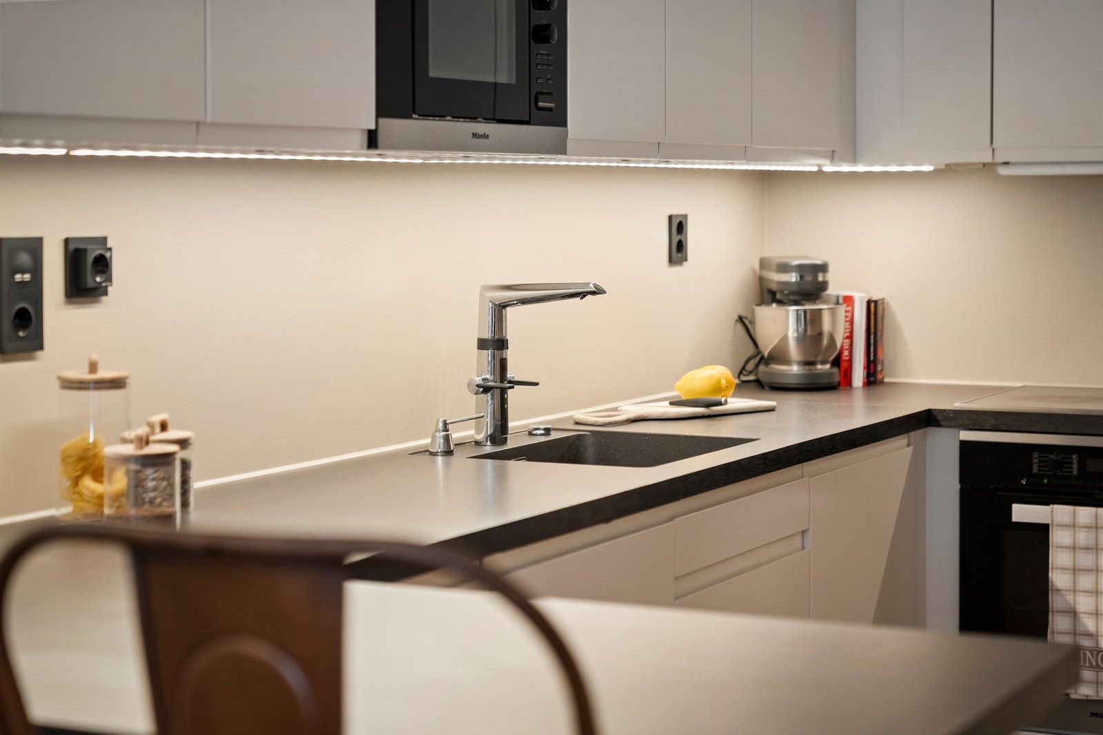 Miele hvitevarer og lys under overskapene. Galleribilde