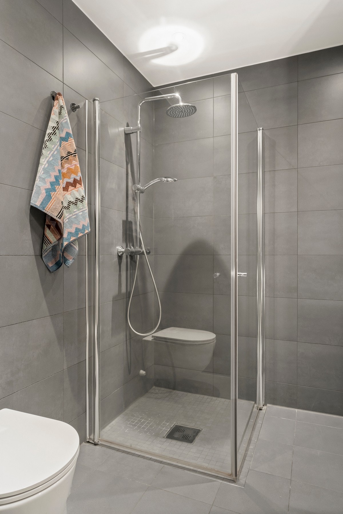 Himling er lyssatt med downlights og i nedsenket dusjhjørne er det mosaikkfliser i samme fargevalør som gulvene for øvrig. Galleribilde