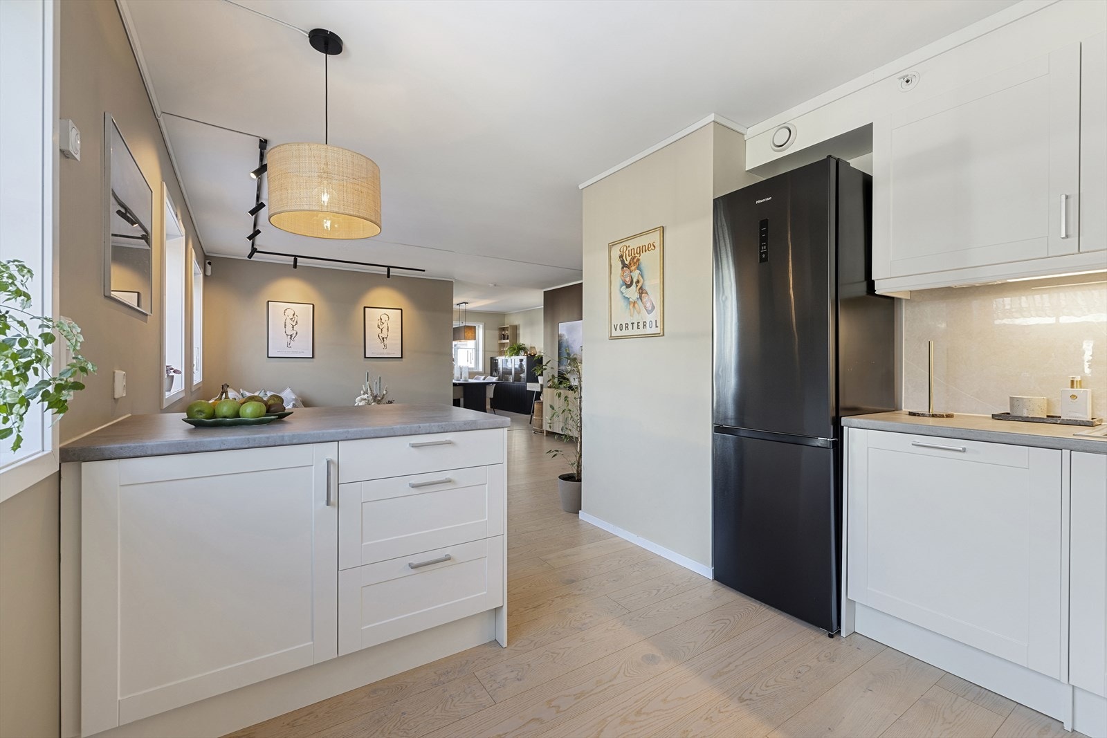 Selger har fått montert en praktisk kjøkkenøy for ekstra benkplass og oppbevaring, som skaper et praktisk skille mellom stue og kjøkken. Galleribilde