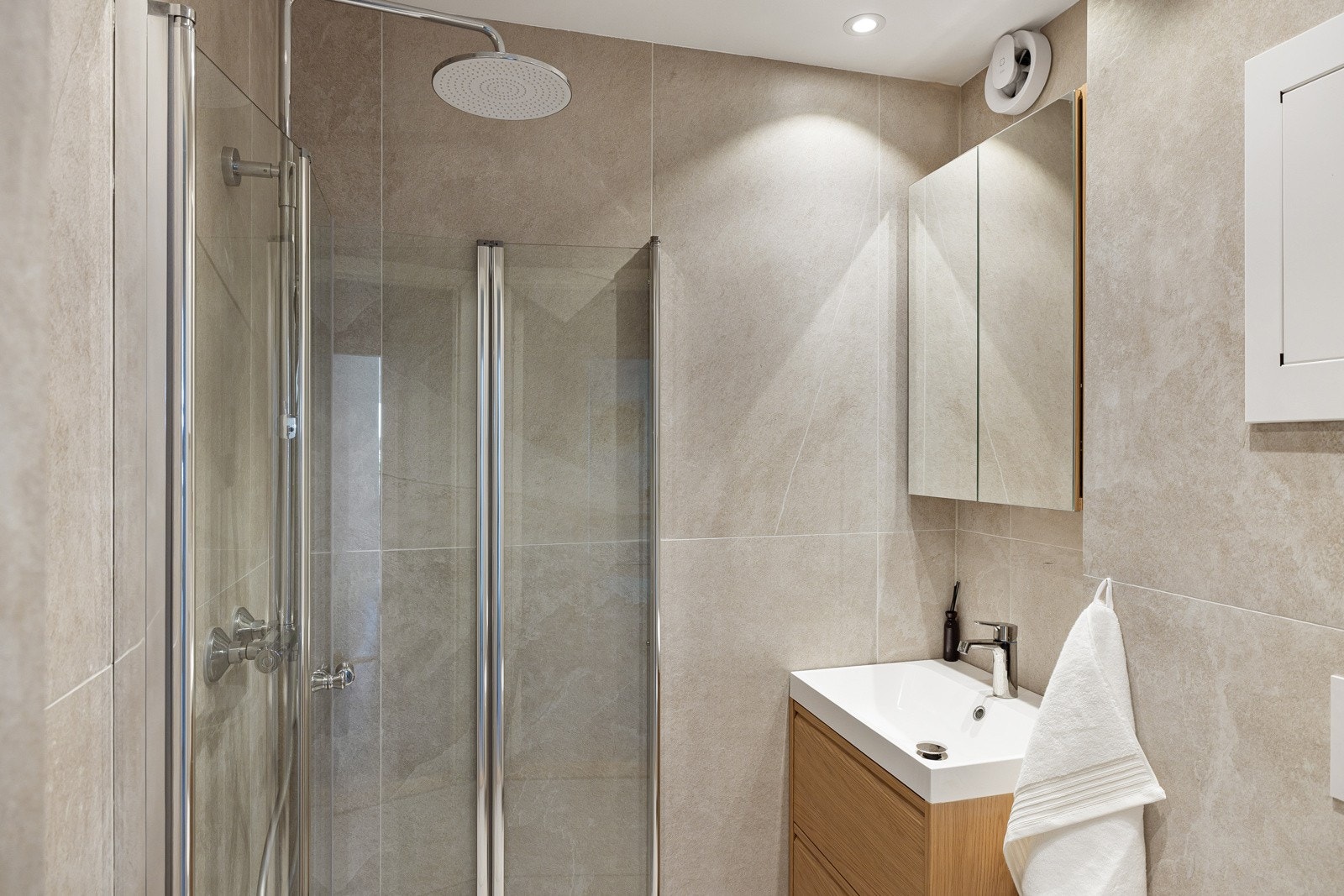 Leiligheten har et stilrent og lekkert flislagt baderom som ble pusset opp i 2025. Baderommet har flotte fliser på gulv og vegger, deilig gulvvarme, downlights i himlingen og avtrekksvifte. Galleribilde