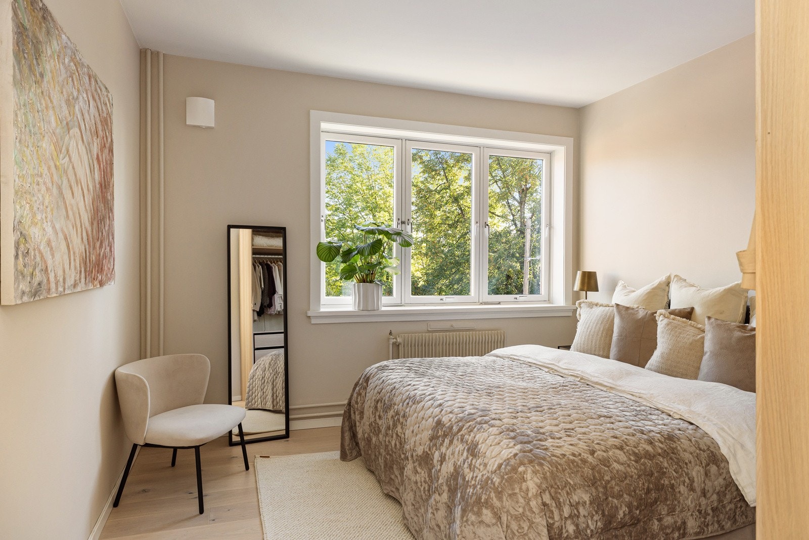 Leiligheten har et lyst og innbydende hovedsoverom av god størrelse. Den store vindusflaten slipper inn naturlig lys, samtidig som det ikke er noe innsyn og frodig utsyn. Galleribilde