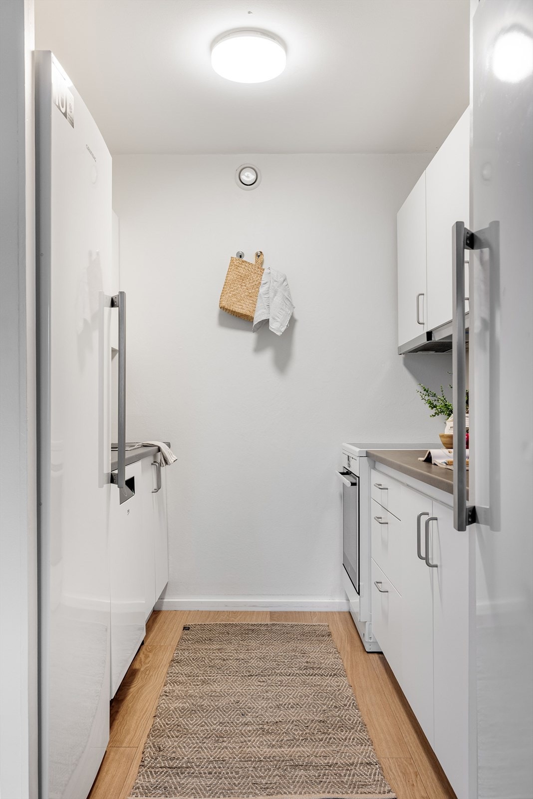 Innredningen består av over- og underskap med hvite, glatte fronter. Laminerte benkeplater med nedfelt oppvaskkum i rustfritt stål. Galleribilde