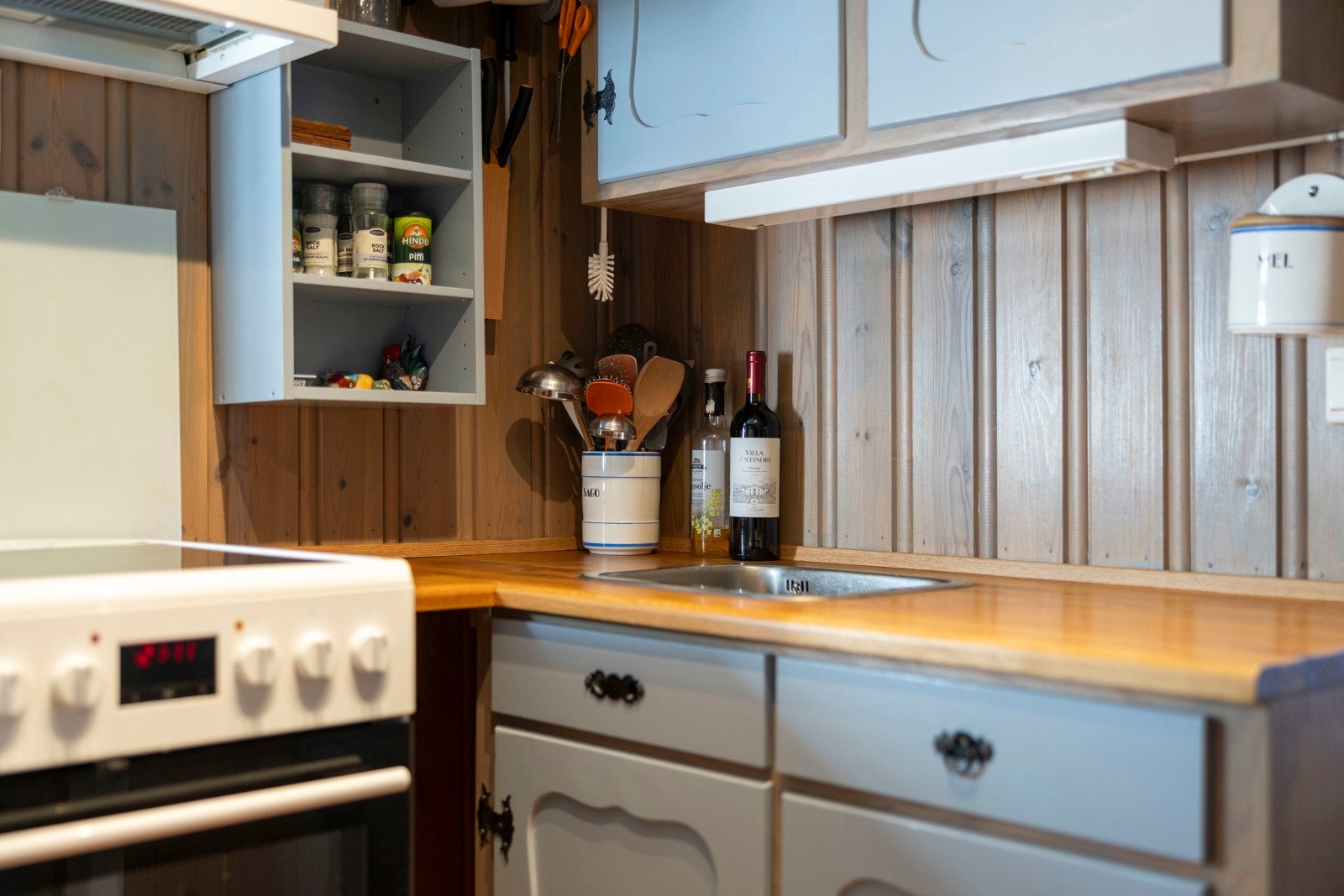 Løsningen byr på godt med skap- og arbeidsplass, supplert av åpne hyller som gir både praktisk lagring og en hyggelig hyttefølelse. Galleribilde