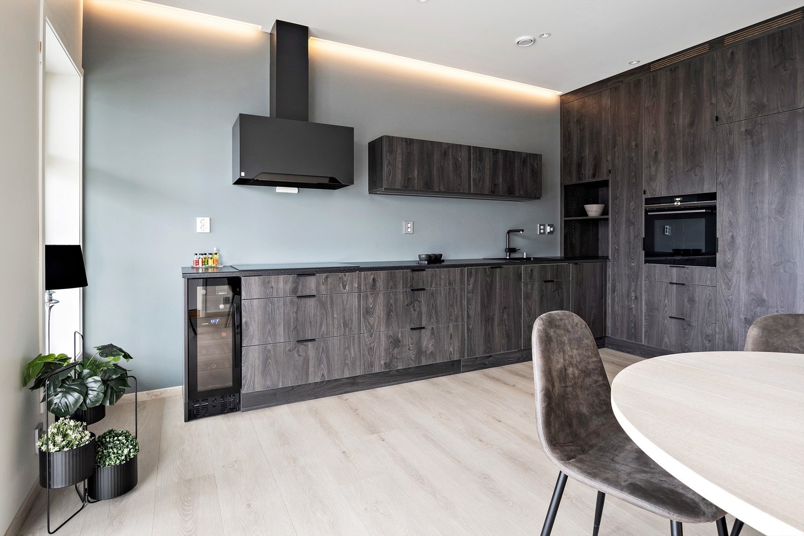 Benkeplaten er av laminat med imitasjon av stein og har overliggende oppvaskkum i kompositt, innredningen har glatte folierte fronter med imitasjon av mørkt tre og har demping i skuffer og skap. Galleribilde