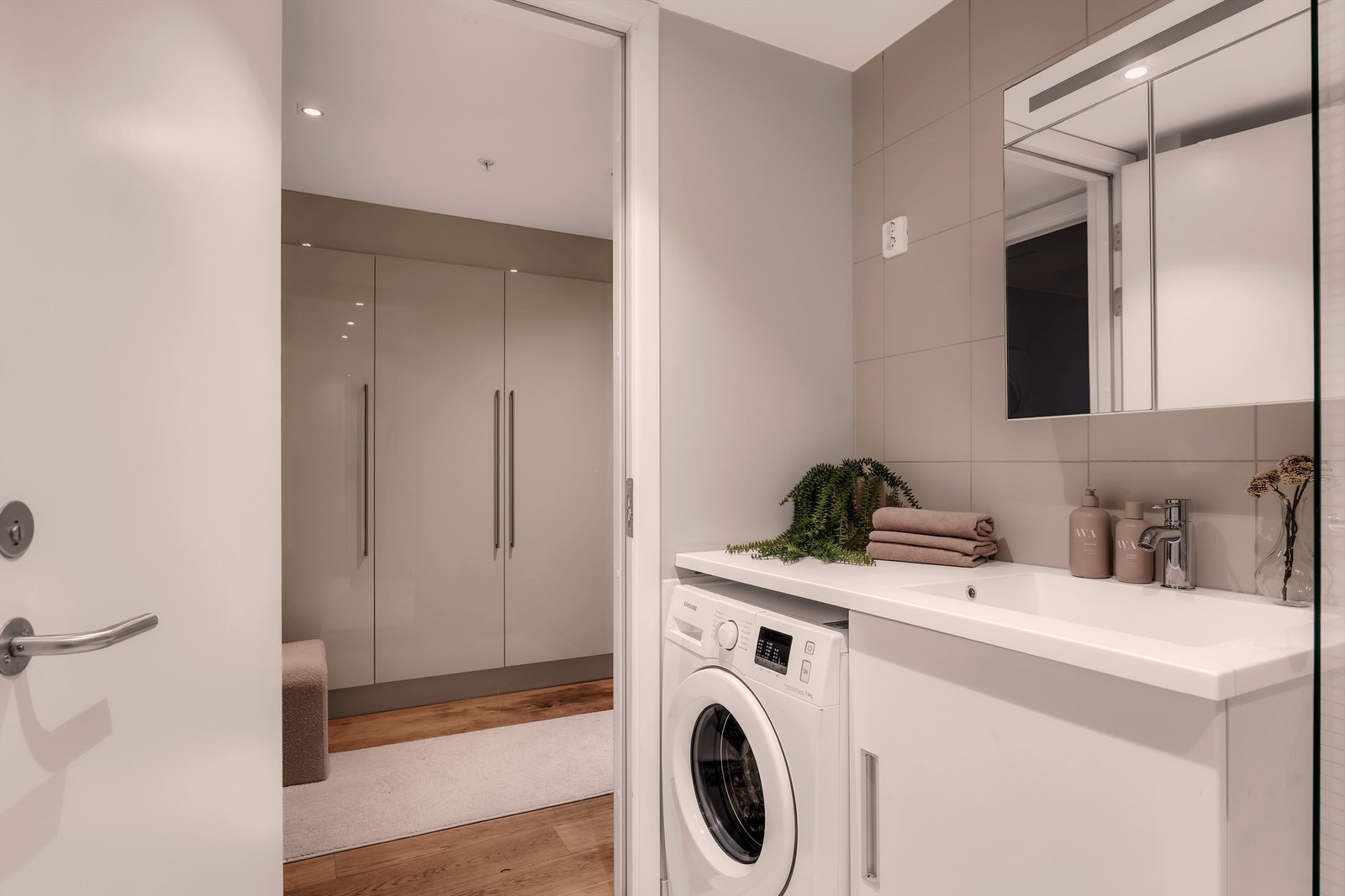 Badet er innredet med gulvstående servantinnredning, speilskap med belysning, vegghengt toalett med innebygget sisterne og dusjhjørne med glassvegger, regndusj og hånddusj. Galleribilde