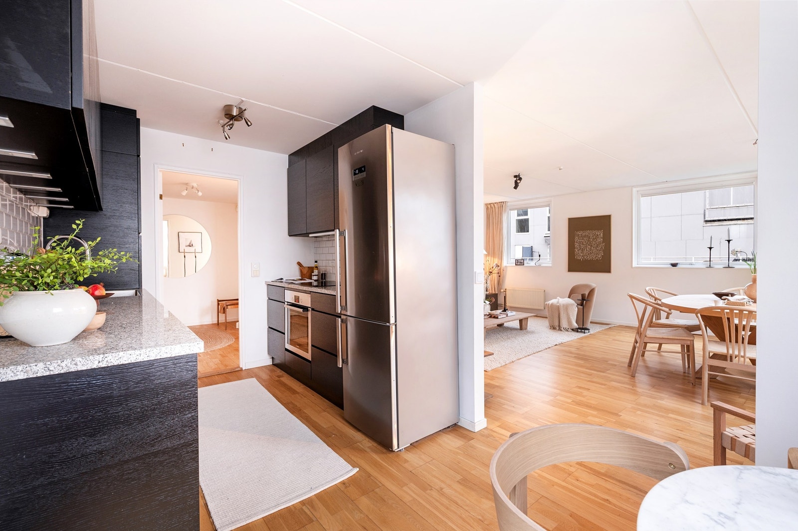 En delvis åpen stue-/kjøkkenløsning skaper en sosial bolig, perfekt for sammenkomster. Galleribilde