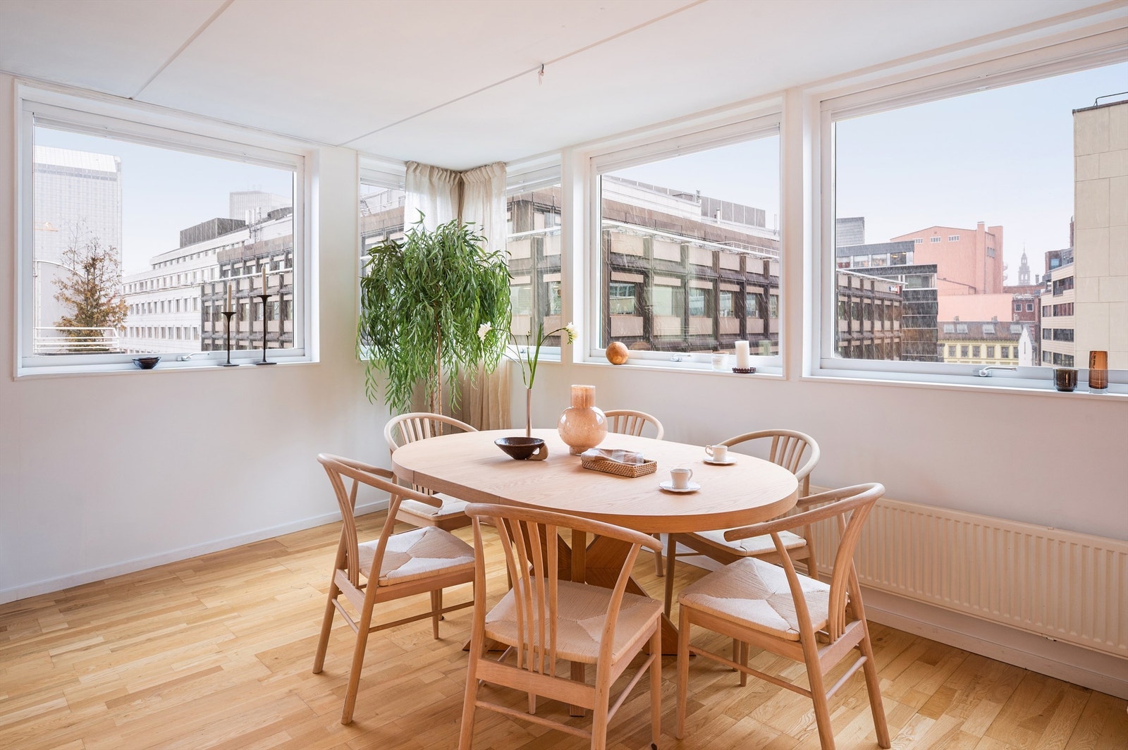 Spiseplassen er naturlig plassert ved vinduene, med utsikt over de urbane omgivelsene. Galleribilde