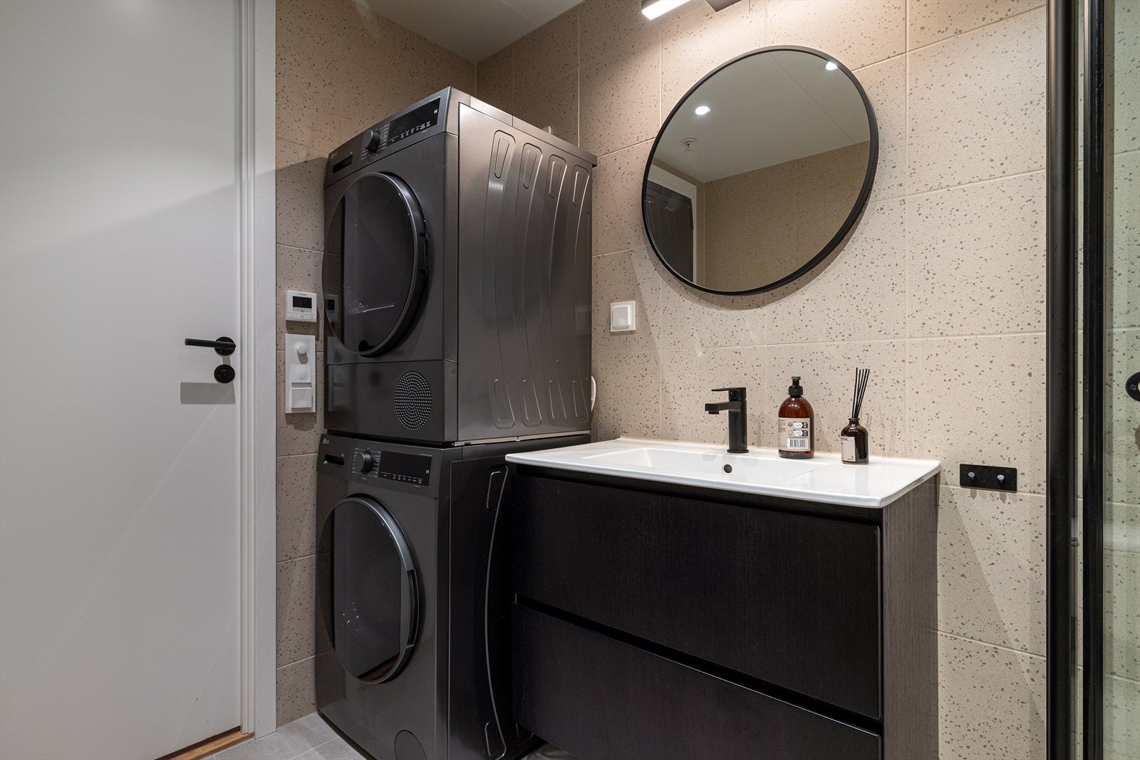 Det er opplegg til vaskemaskin og tørketrommel. Knagger på bad er i samme sorte matte utførelse som resten av innredningen. Galleribilde