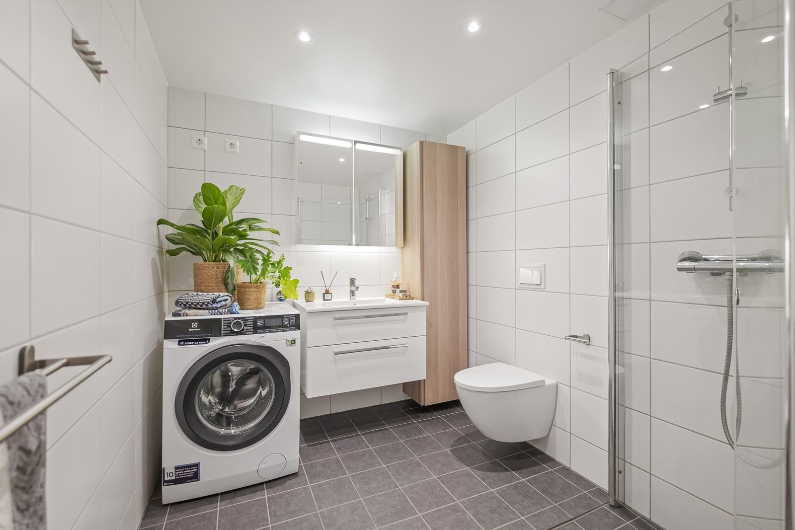 Romslig og delikat baderom med varmekabler i gulv og downlights i himling. Galleribilde