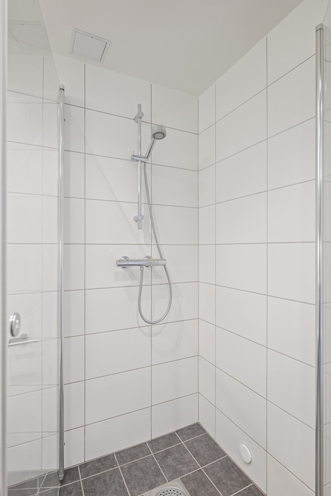 Nedsenket dusjhjørne med svingbare rette dusjdører, termostatstyrt dusjbatteri og dusjutstyr. Galleribilde