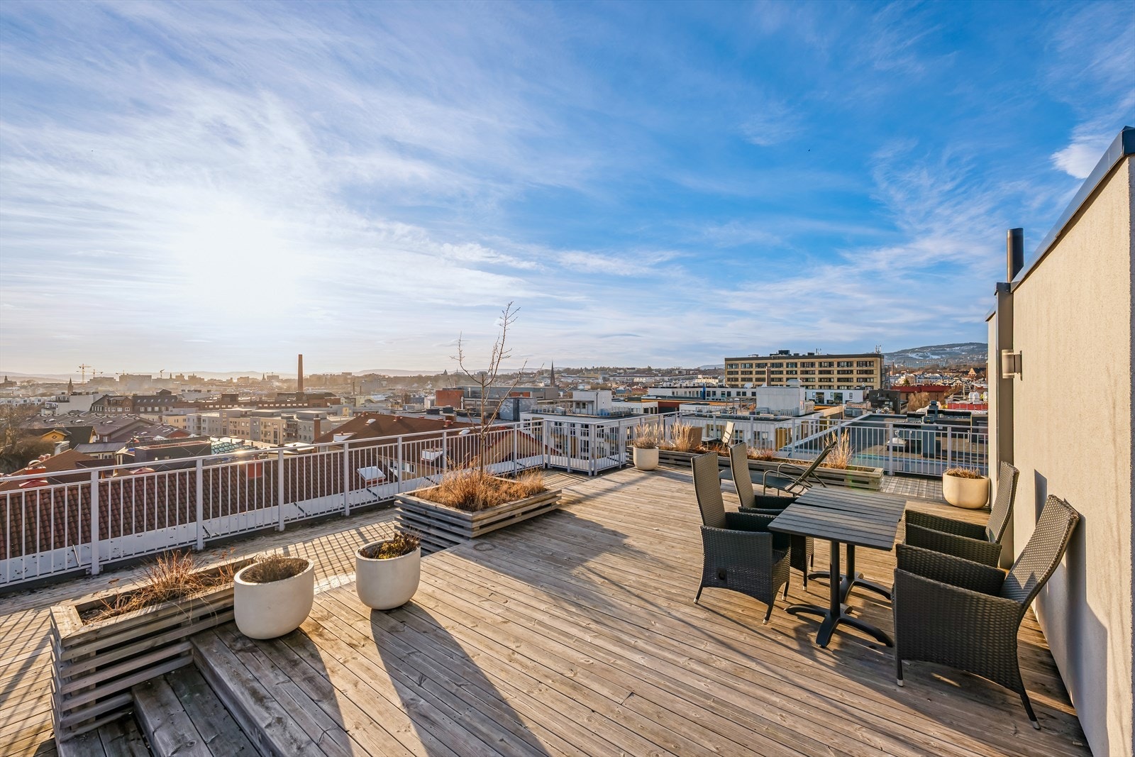 Felles takterrasse med hyggelige sittegrupper og pen beplantning. Galleribilde