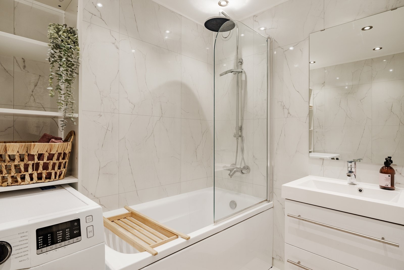 Hovedbadet er utstyrt med servantinnredning med servant og skuffer til oppbevaring, ettgreps blandebatteri, blandebatteri/dusjarmatur og badekar Galleribilde