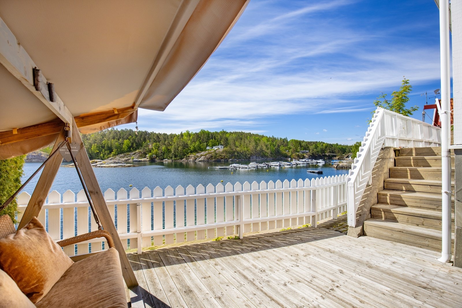 Fine terrasser rundt boligen i tre og stenlagte ute områder og pen beplantning Galleribilde