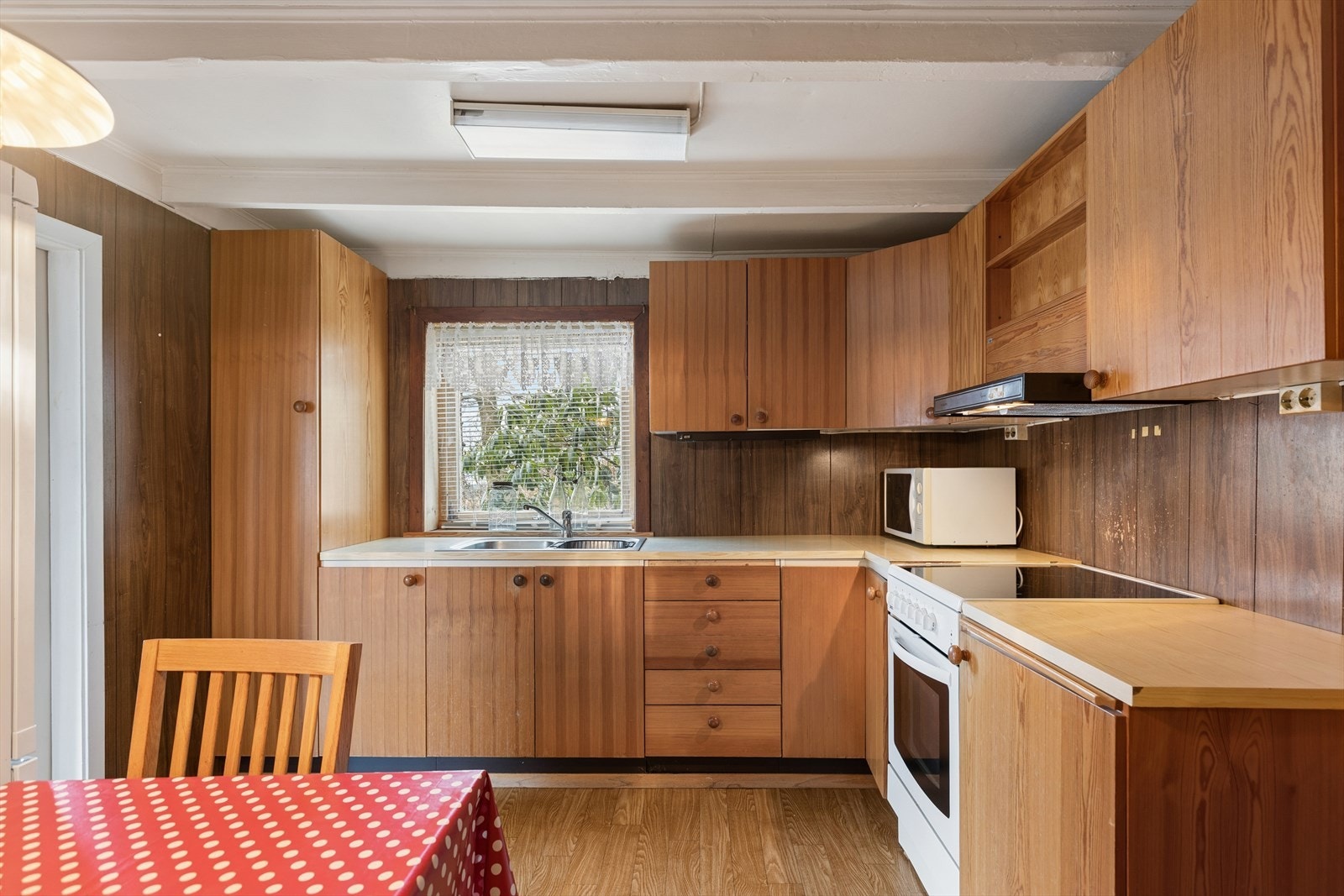 Kjøkkenet har innredning med glatte fronter. Benkeplaten er av laminat. Det er kjøl/fryseskap og komfyr. Det er kjøkkenventilator med avtrekk ut. Galleribilde