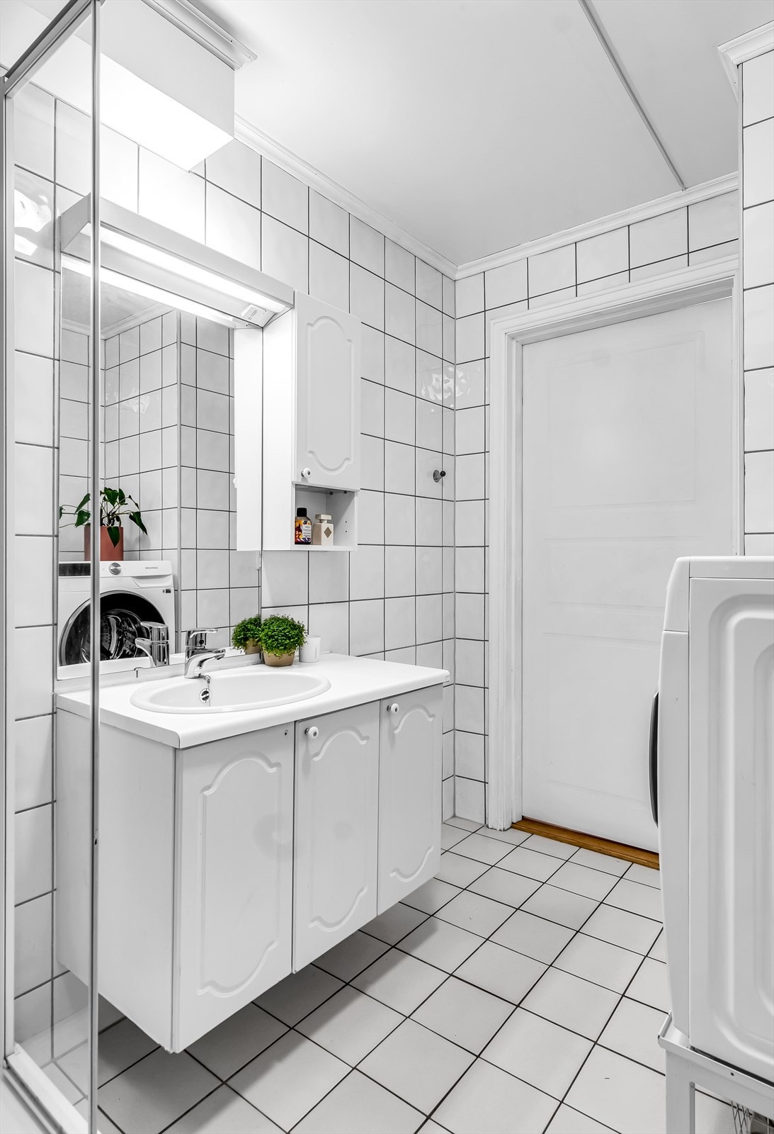 Baderomsinnredning med servantskap, ovenpåliggende servant og ett-greps armatur. Galleribilde