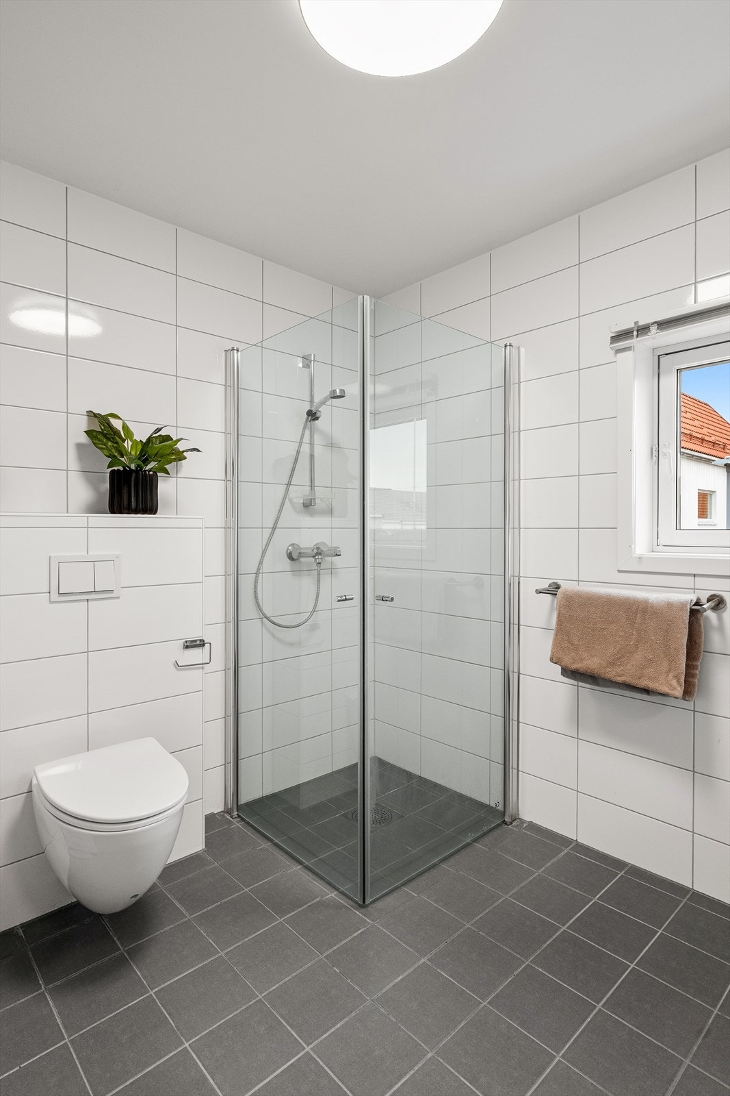 Bad med dusjløsning og vegghengt toalett. Galleribilde