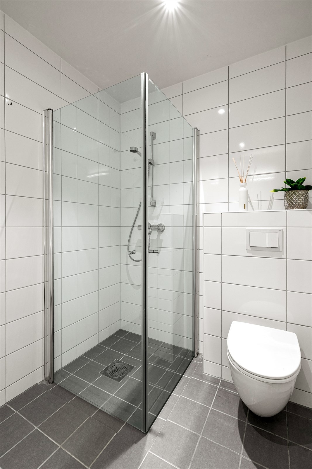 Badet er utstyrt med vegghengt toalett og dusjløsning. Galleribilde