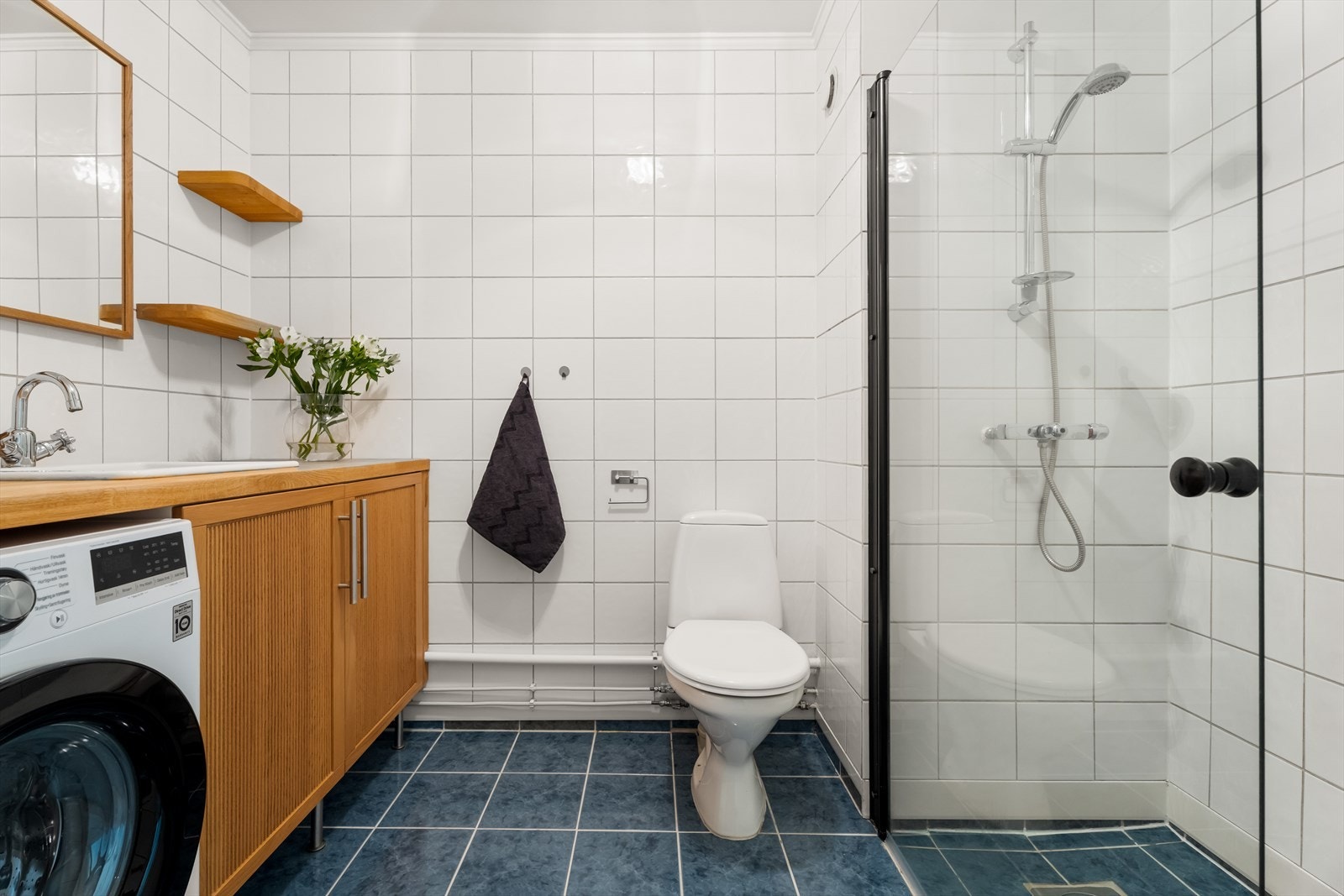 Det er innredet med baderomsmøbel med nedfelt servant, dusjhjørne med svingbare glassdører, toalett og opplegg for vaskemaskin. Galleribilde