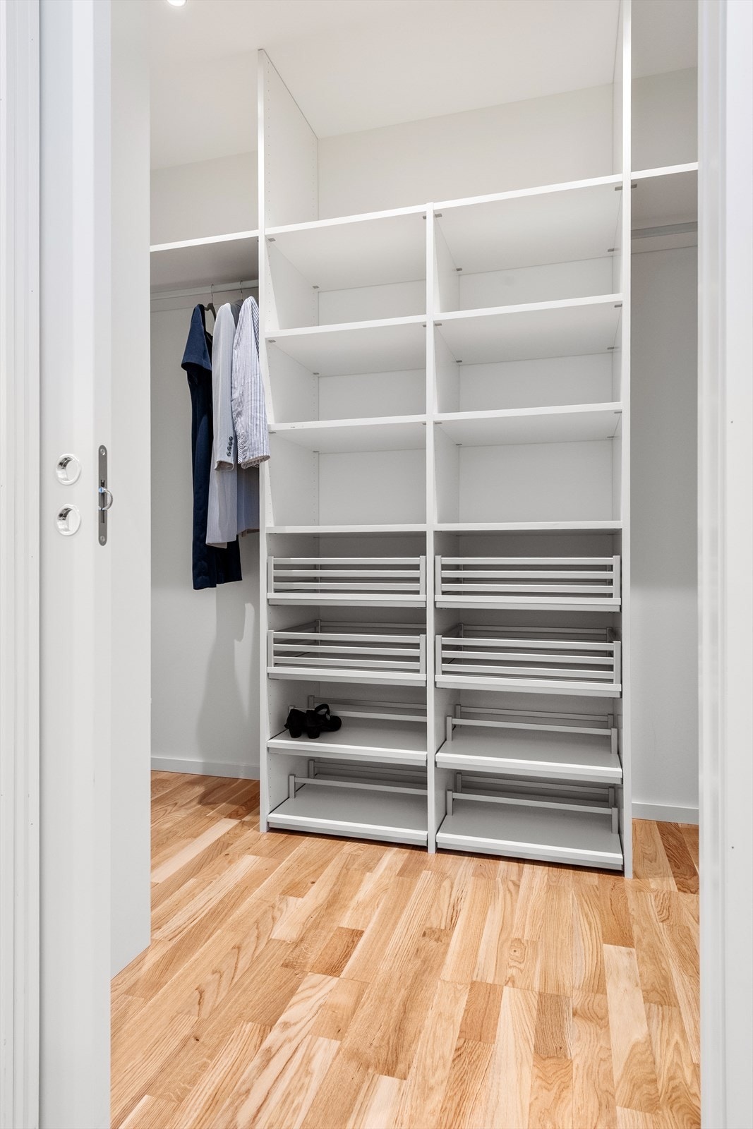 Walk-in-garderobe med fast innredning og gode oppbevaringsmuligheter Galleribilde
