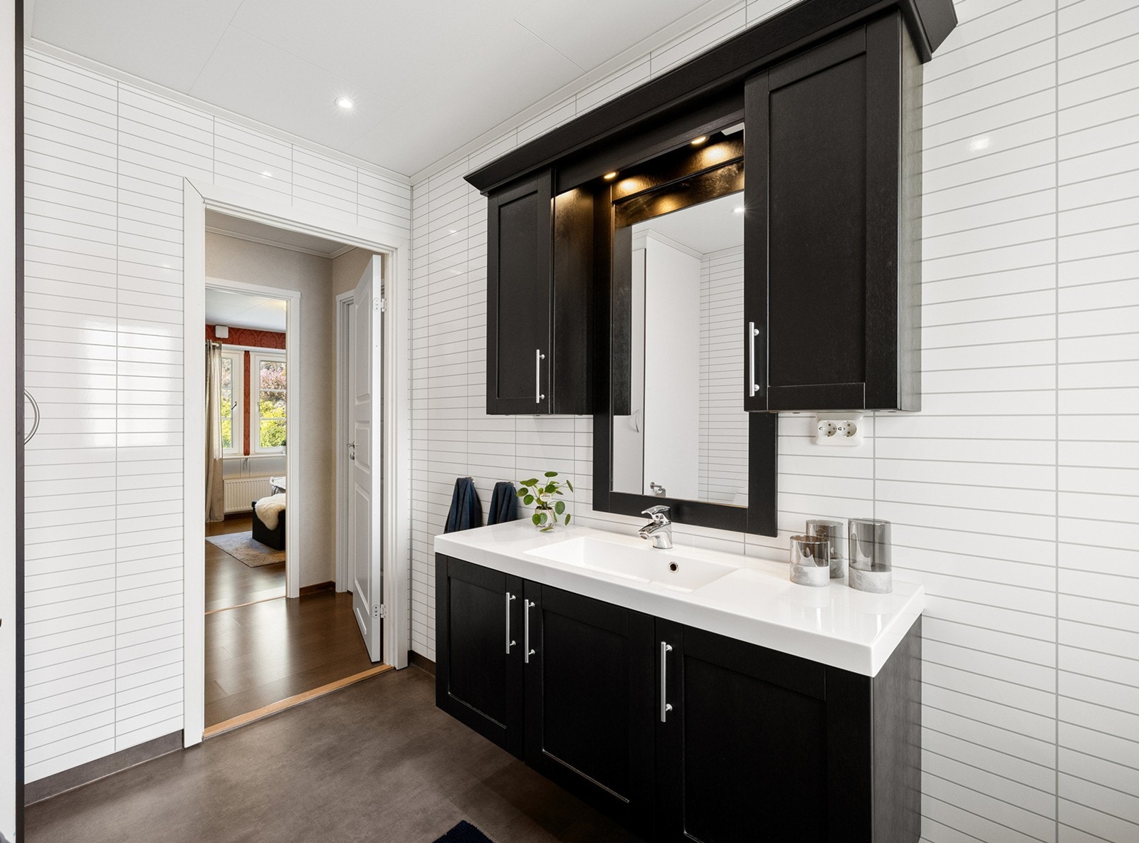 Badet er delikat innredet med baderomsplater på vegger, og gulvbelegg med behagelig gulvvarme som gir ekstra komfort. Galleribilde