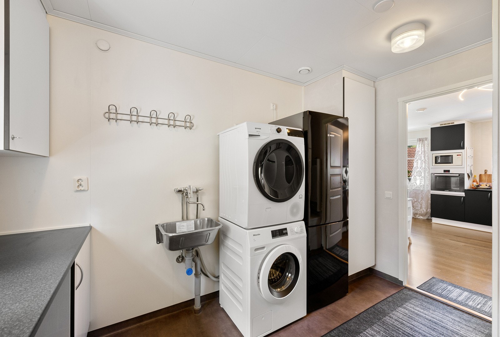 Vaskerommet er praktisk innredet med opplegg for vaskemaskin og tørketrommel, samt utslagsvask og god arbeidsplass. Galleribilde