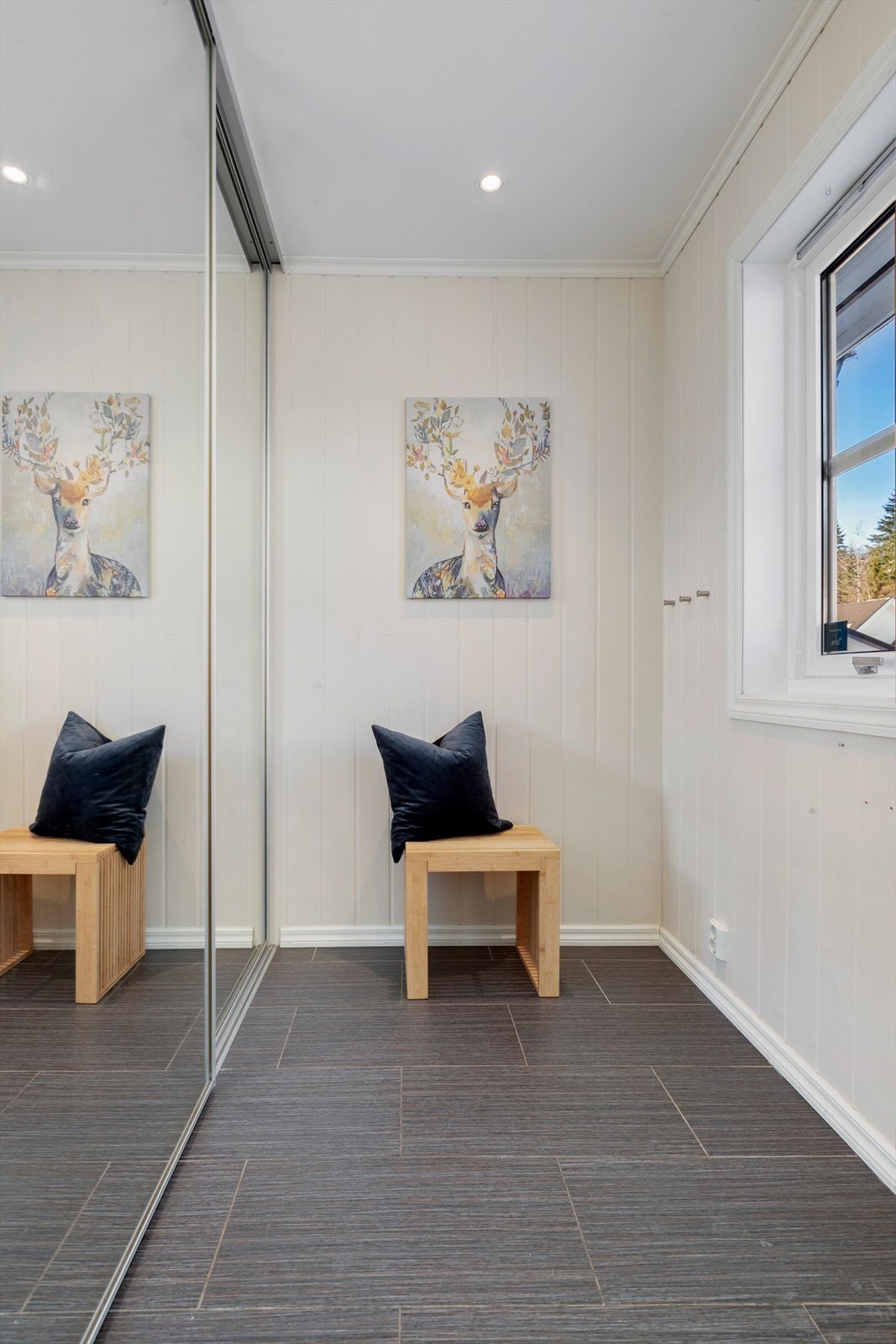 En stor skyvedørsgarderobe med speilfronter gir rikelig med plass til oppbevaring av yttertøy og sko. Galleribilde