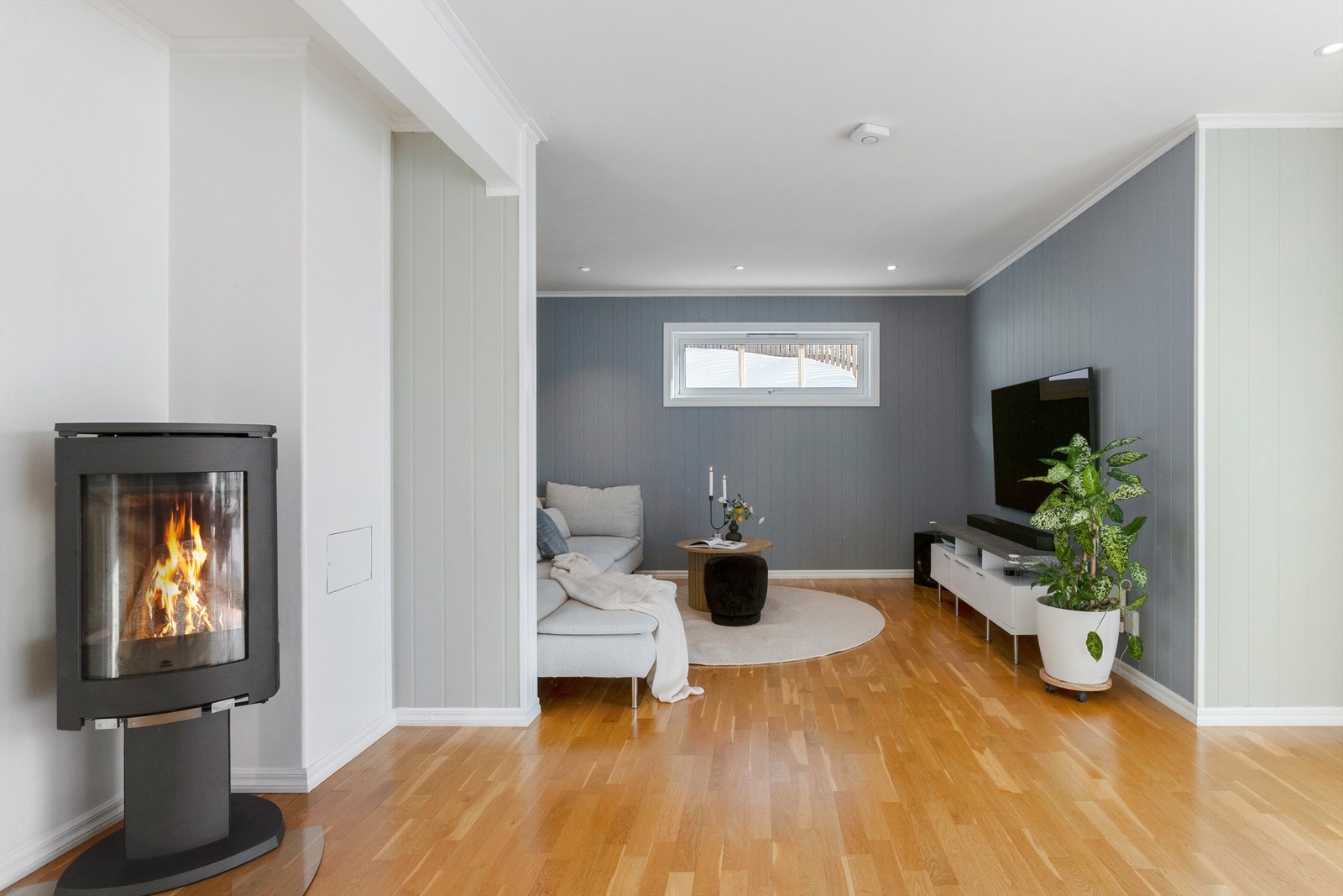 I stuen er det en moderne peisovn med glassdør, som gir både varme og en hyggelig atmosfære. Galleribilde