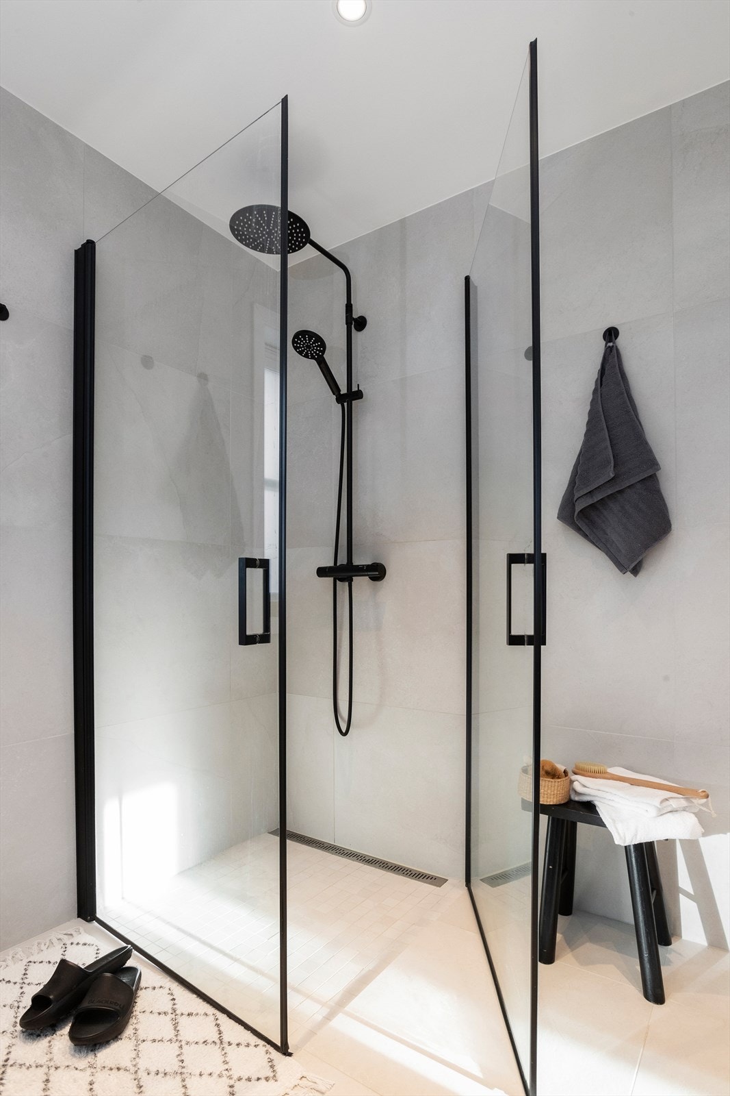 Romslig dusjhjørne med glassdører og regnfallsdusj for ekstra komfort. Galleribilde