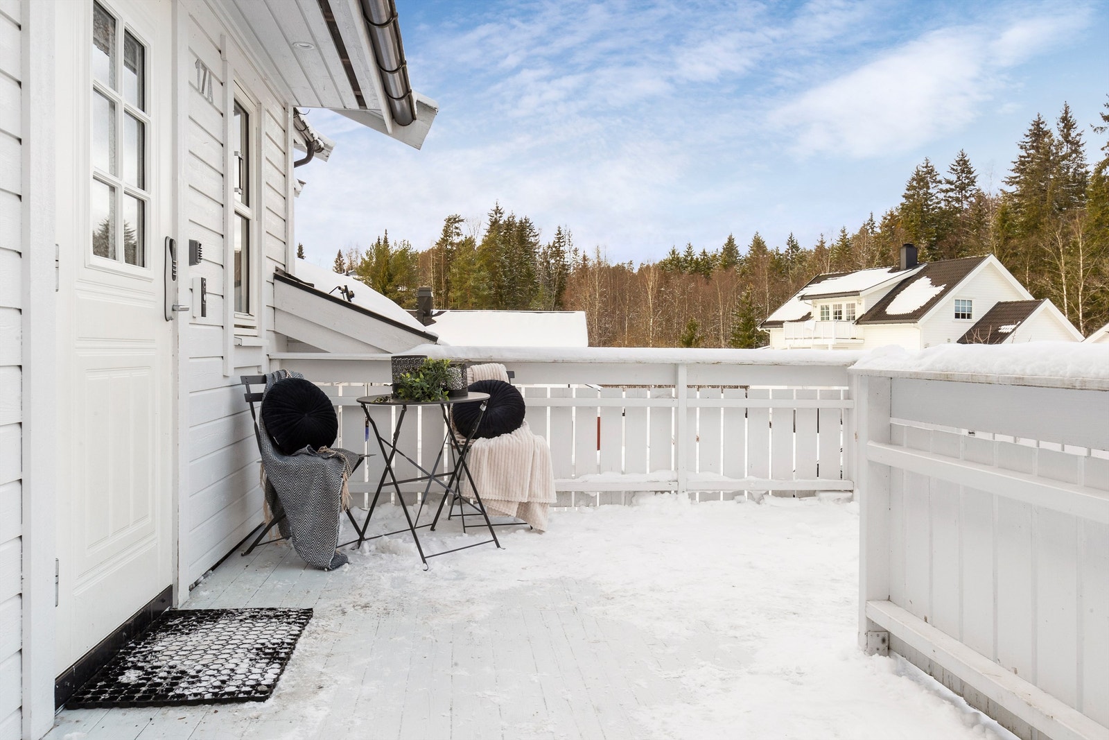 Overbygget inngangsparti med plass til en liten sittegruppe. Galleribilde