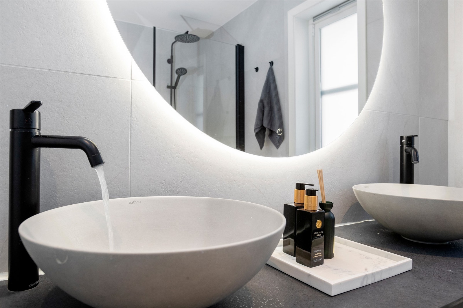 Delikate detaljer som bakbelyst speil og moderne armaturer understreker den høye standarden. Galleribilde