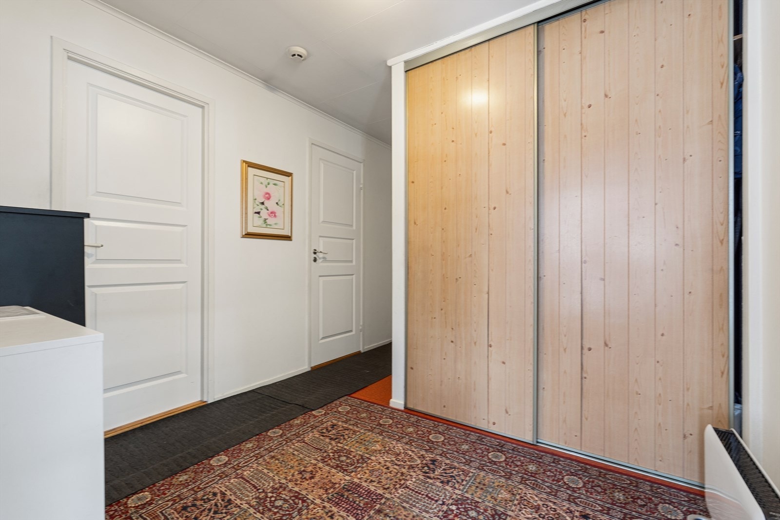 Gangpartiet byr på innebygget skyvedørsgarderobe. Galleribilde