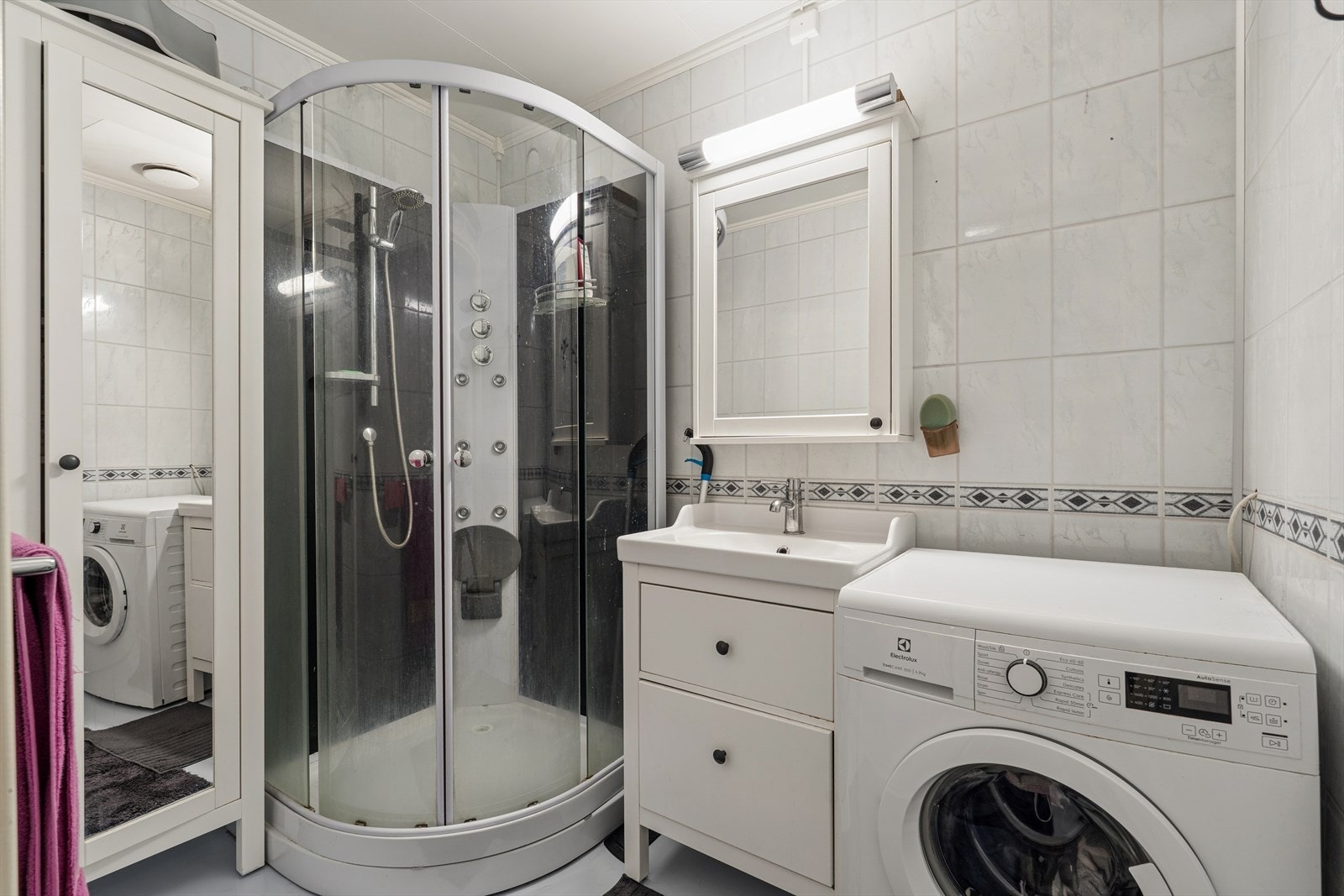 Utstyrt med dusjkabinett, opplegg for vaskemaskin og lys baderomsinnredning. Galleribilde