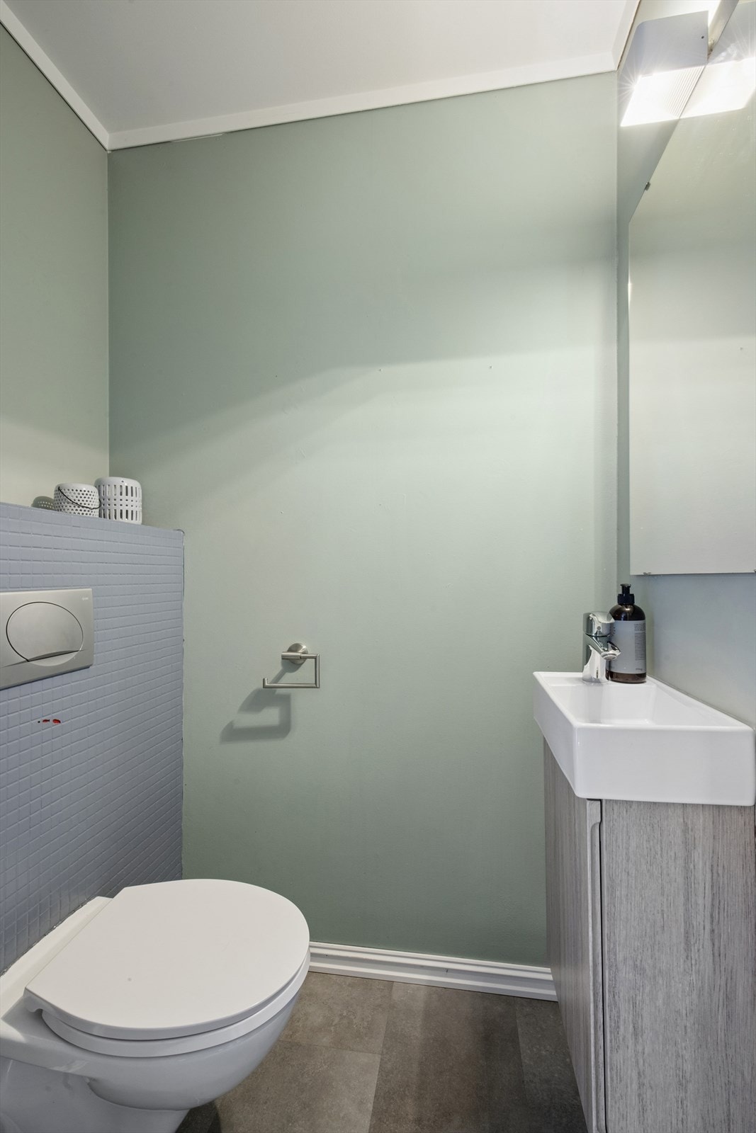 Like ved baderommet finner man et toalettrom som er innredet med vegghengt toalett og baderomsinnredning med servant. Galleribilde