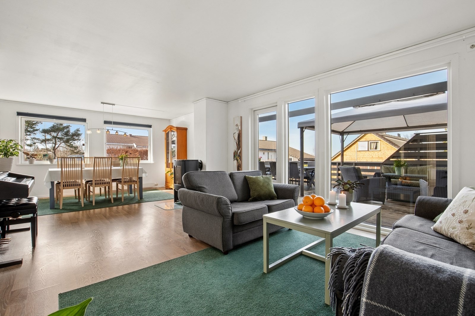 Stue og kjøkken ligger i åpen løsning. Et lyst og innbydende rom med store vindusflater som gir godt med naturlig lys, i tillegg til terrassedør med utgang ut til uteområdet. Galleribilde