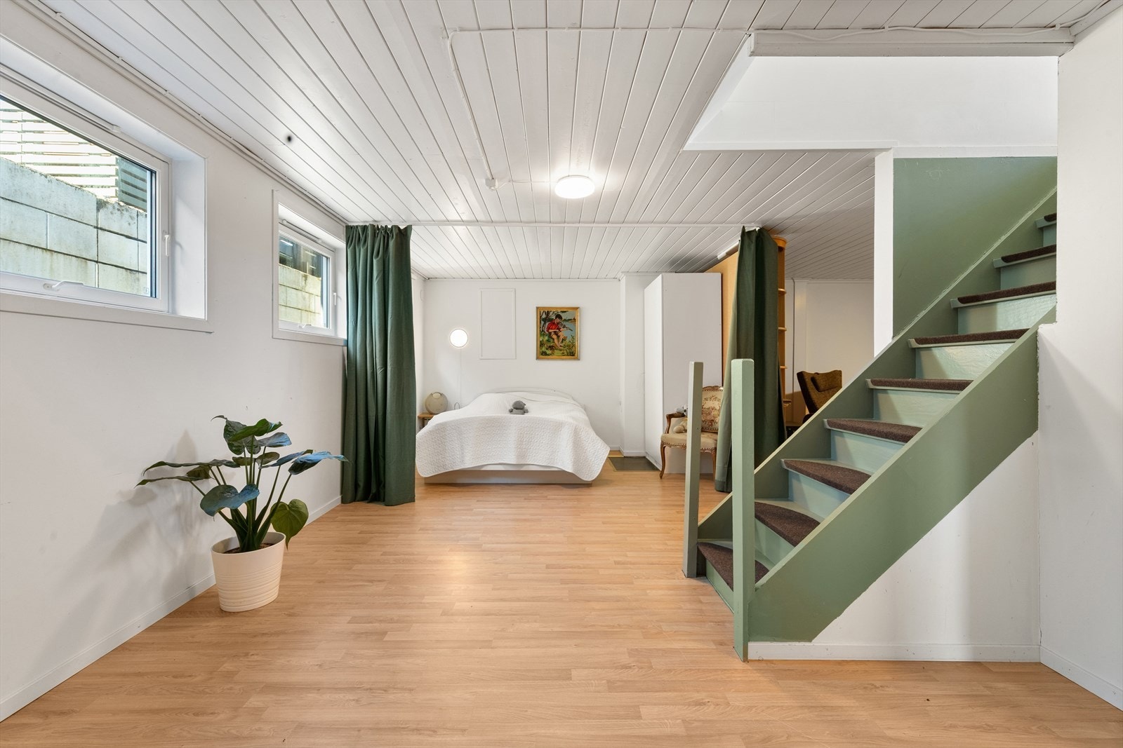 Følger man trappen ned til kjelleretasjen kommer man inn i et stort og åpent rom som i dag er innredet som stue og sovealkove (se punkt "ferdigattest"). Galleribilde