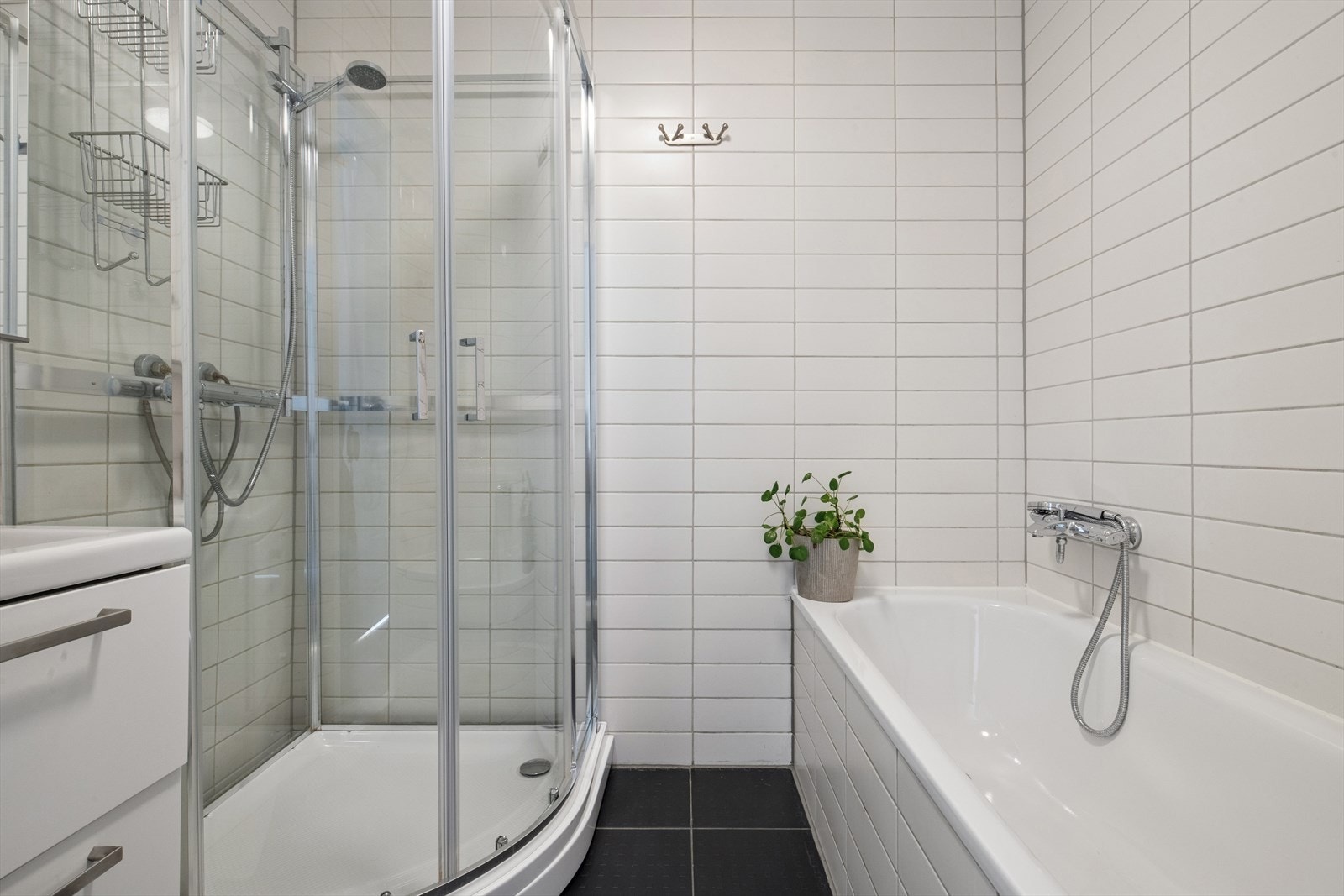 Badets grunnbase er fra byggeår, men er modernisert med flis på flis i nyere tid. Badet er tidløst innredet med grå fliser på gulvet og hvite fliser på vegg. I gulvet har man også varmekabler for ekstra komfort. Galleribilde