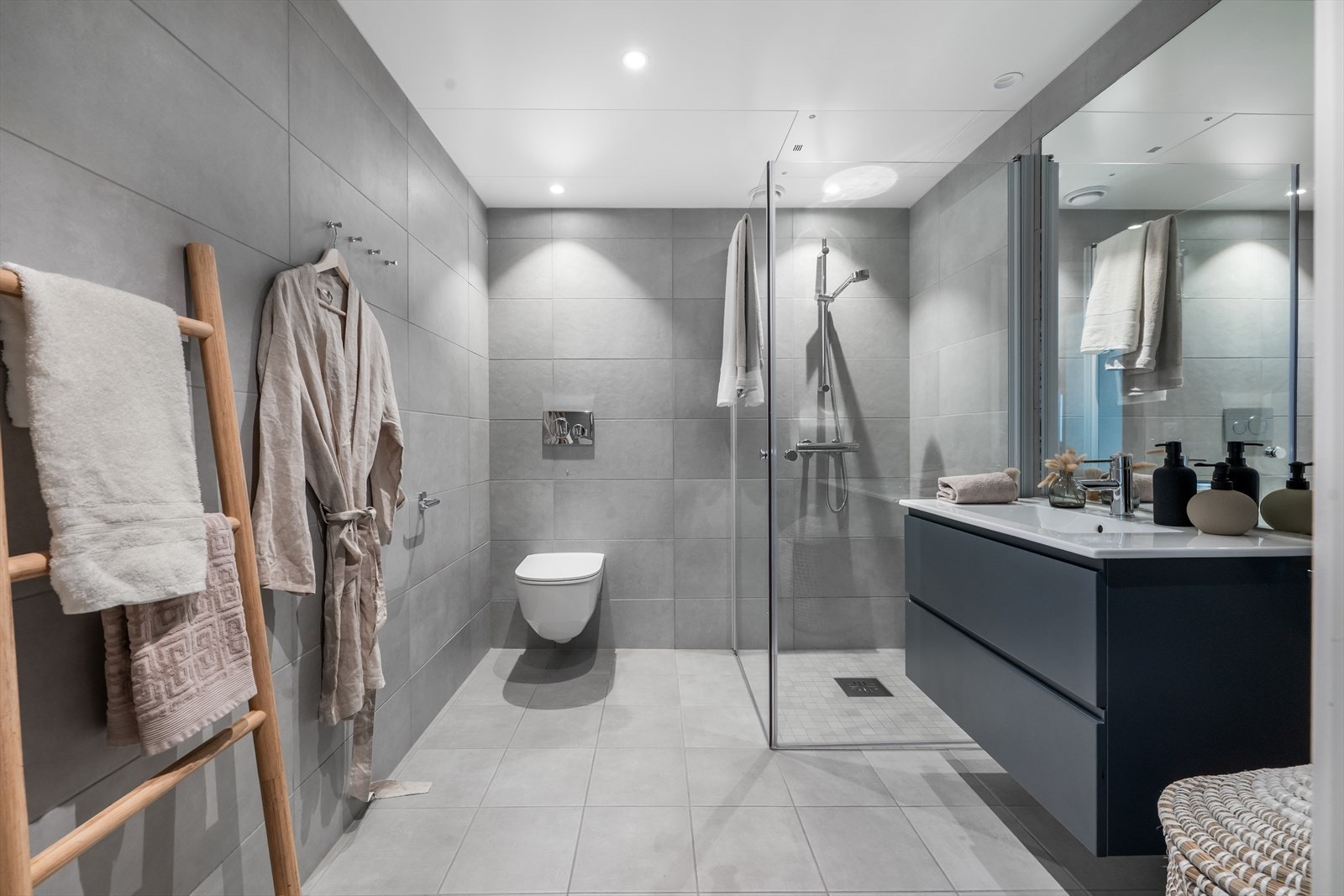 Moderne, flislagt bad med varme i gulvet, vegghengt toalett og plassbesparende dusjdører. Galleribilde