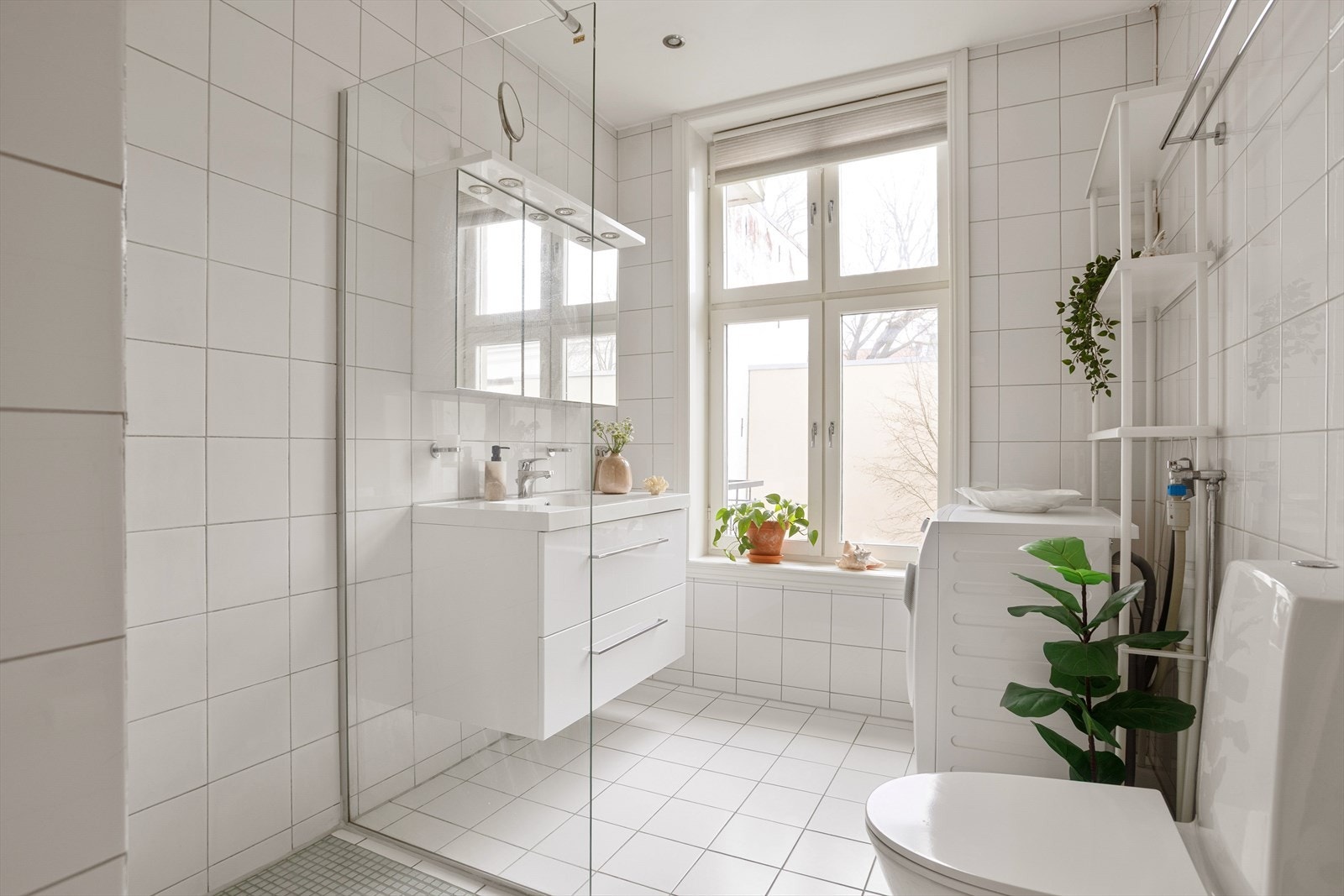 Delikat flislagt baderom med varme i gulv, downlights i himling og opplegg for vaskemaskin Galleribilde