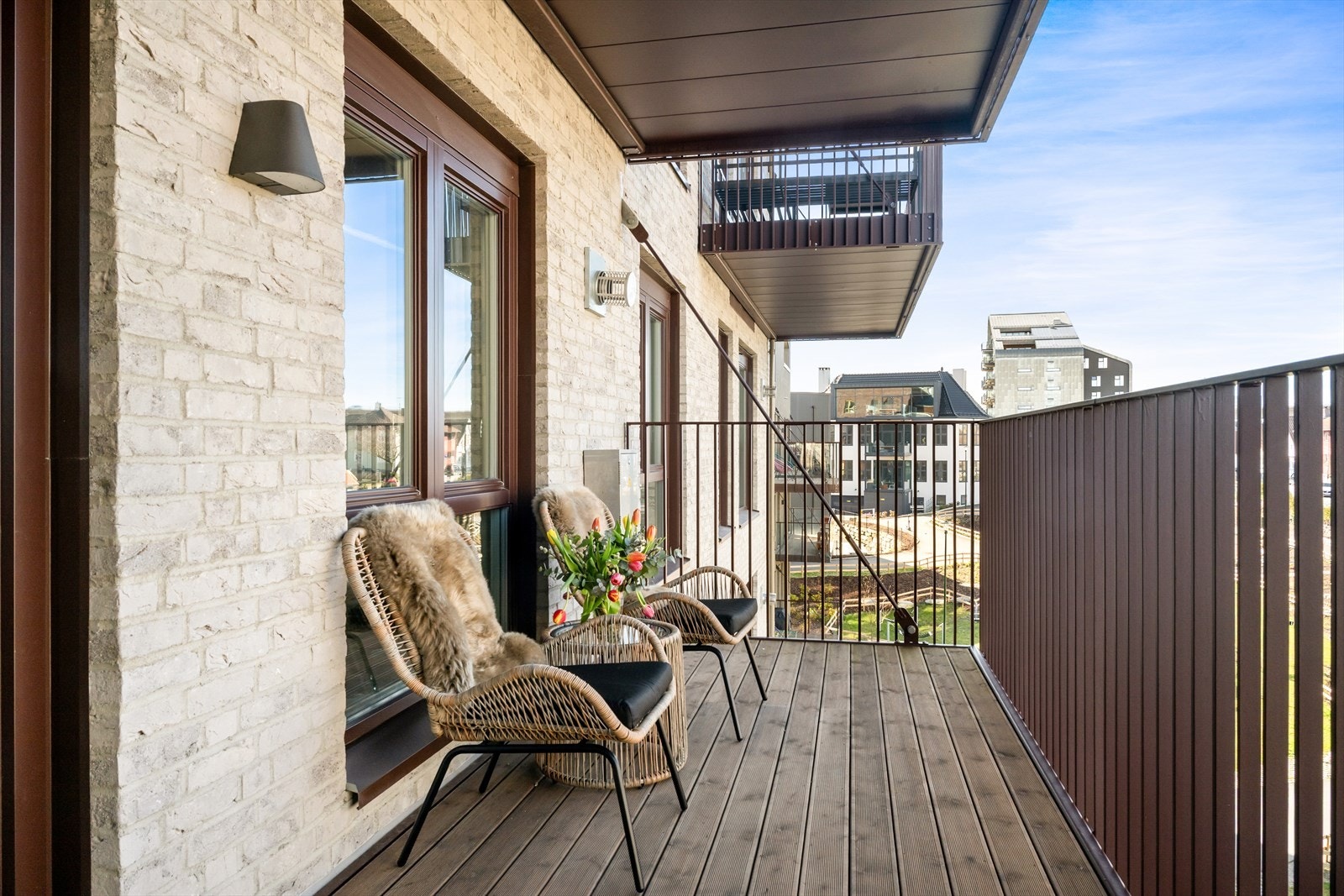 Utgang til en overbygget balkong som vender mot et trivelig fellesområde og sjø Galleribilde