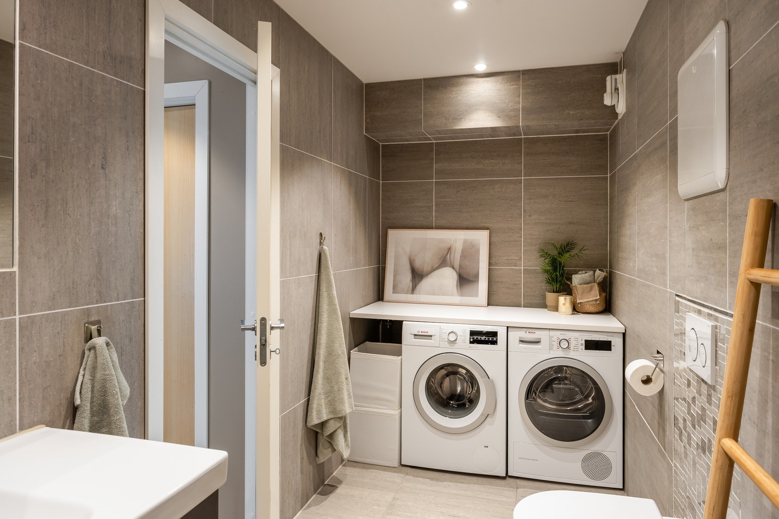 Her er baderomsinnredning, vegghengt toalett, dusjhjørne med innfellbare glassdører og opplegg for vaskemaskin/tørketrommel. Varmekabler i gulv. Galleribilde