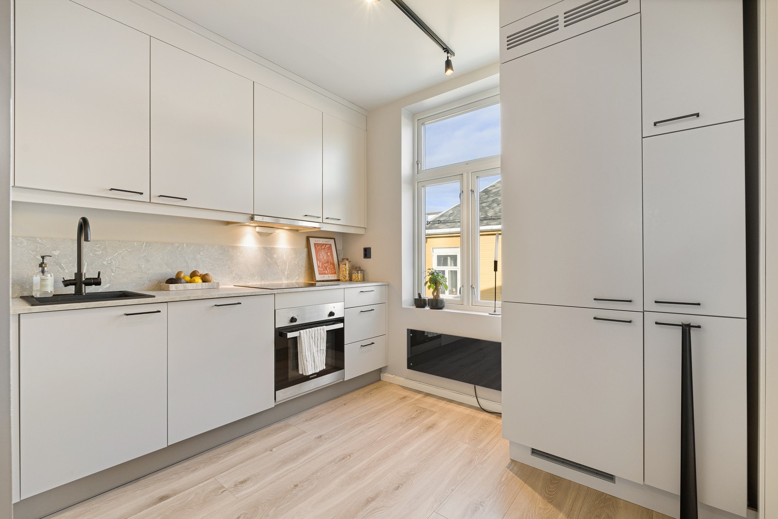 Delikat kjøkken med rikelig med skapplass og gode arbeidsflater. Galleribilde