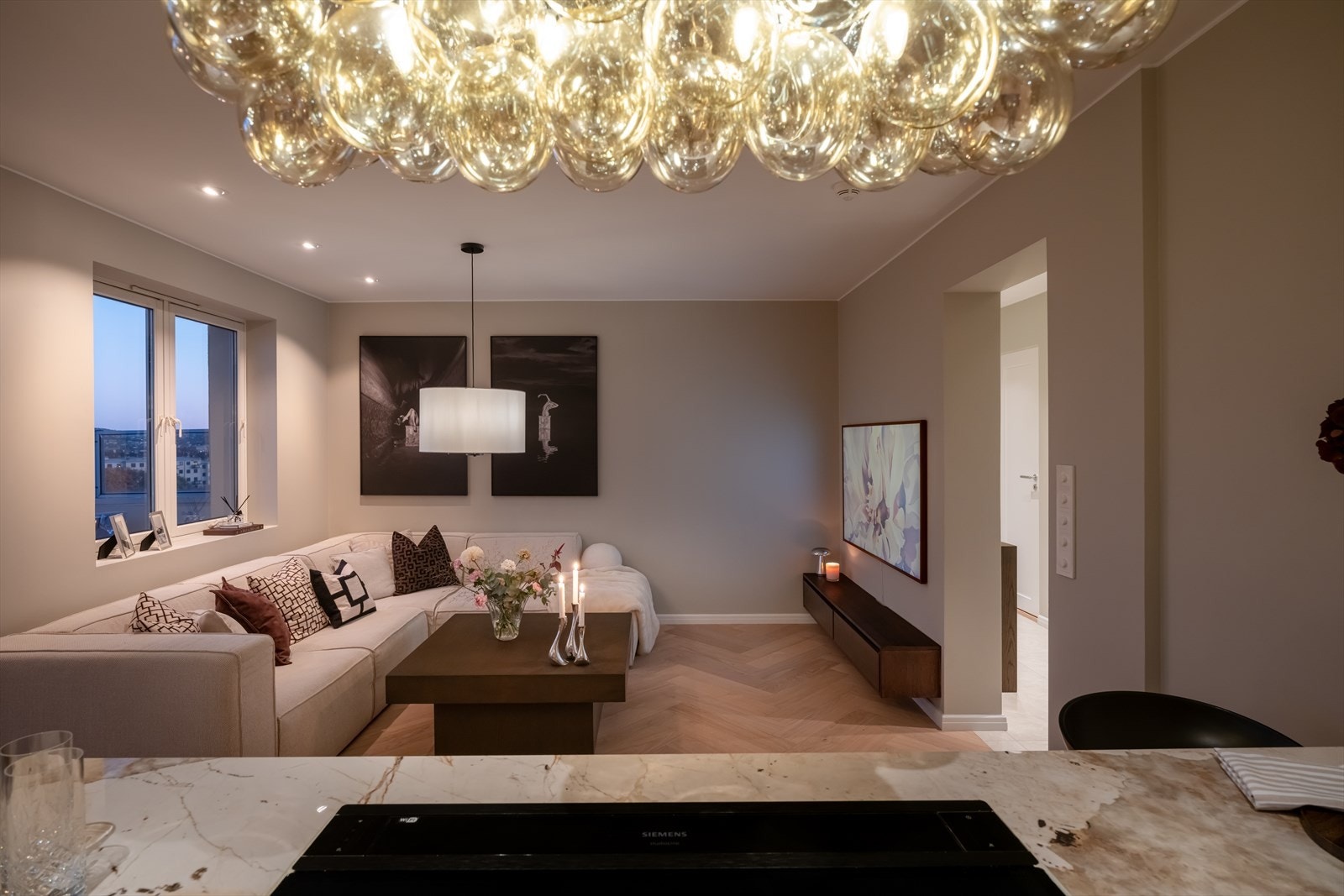 Fra kjøkkenøya har man full oversikt over stuen, noe som inviterer til sosial matlaging. Galleribilde