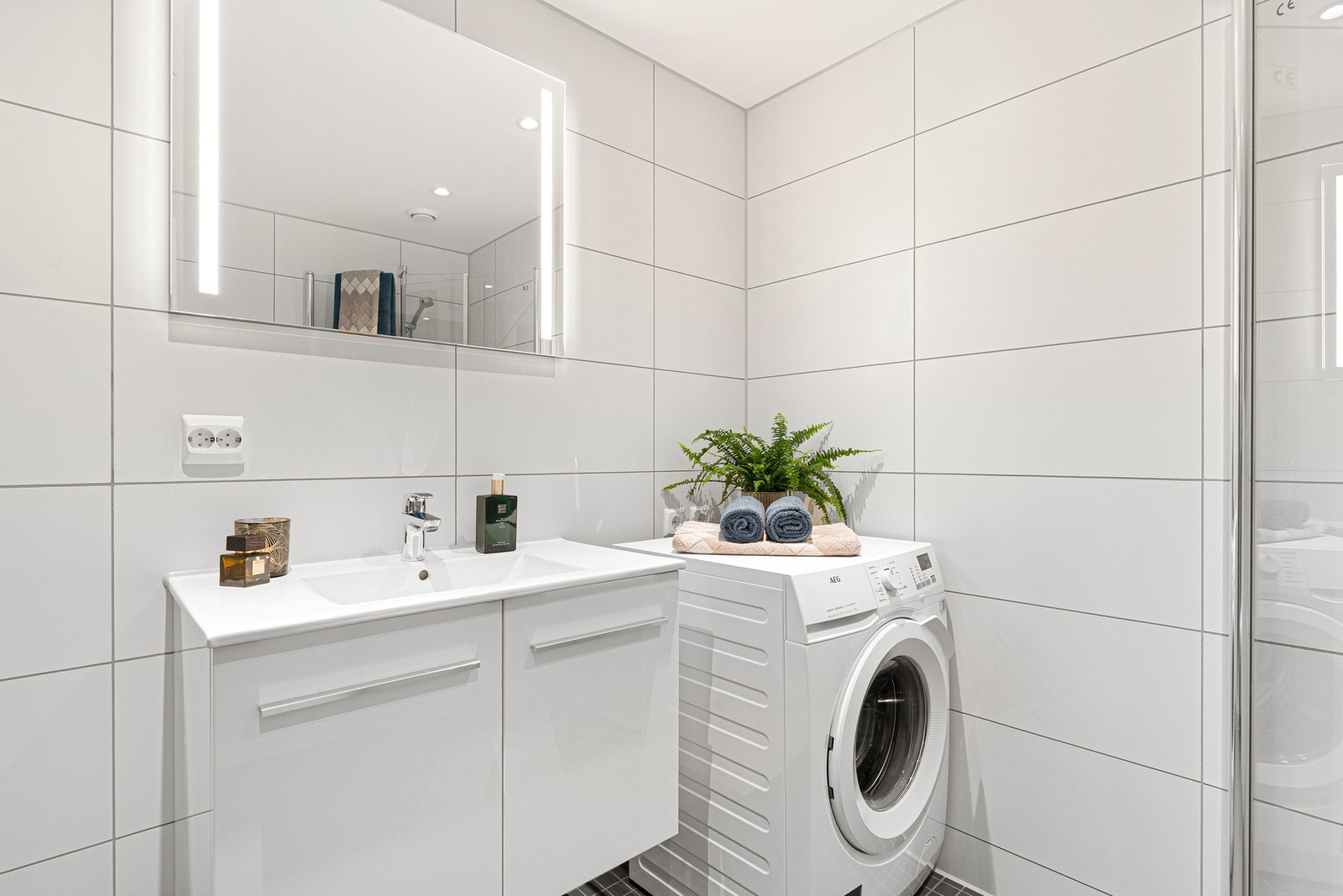 Badet er utstyrt med bl.a. servant, klosett, dusjhjørne samt opplegg til vaskemaskin. Galleribilde