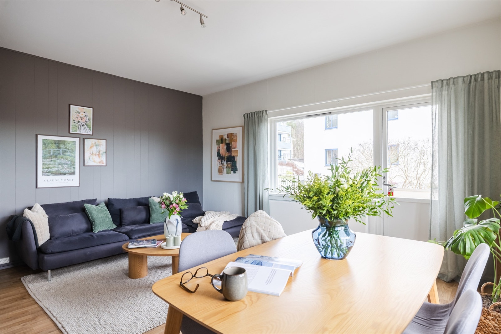 Åpen og hyggelig stue med flere store vinduer på flere veggflater som slipper inn rikelig med lys. Galleribilde